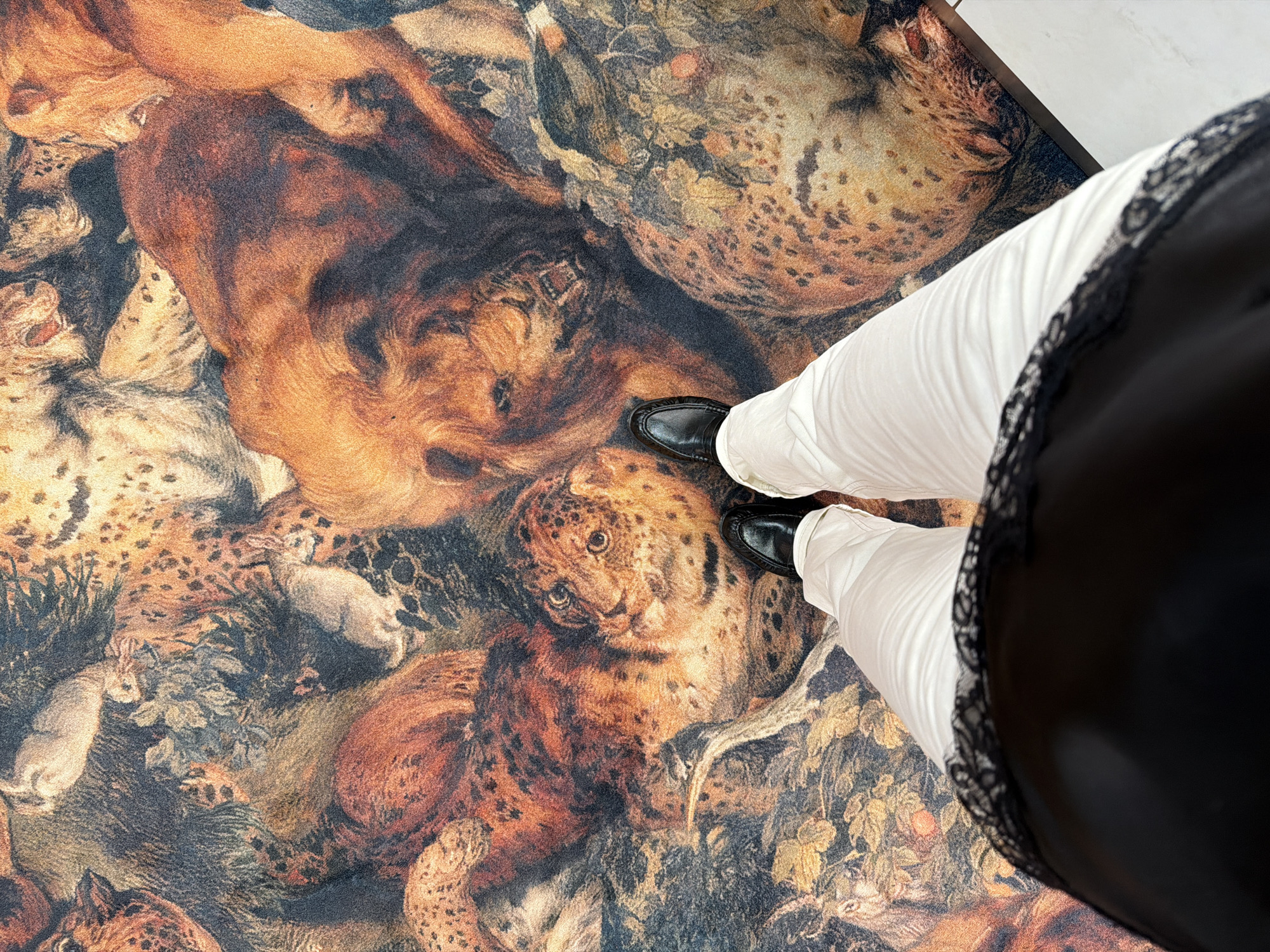 Person stands on ornate animal-patterned rug in Riga