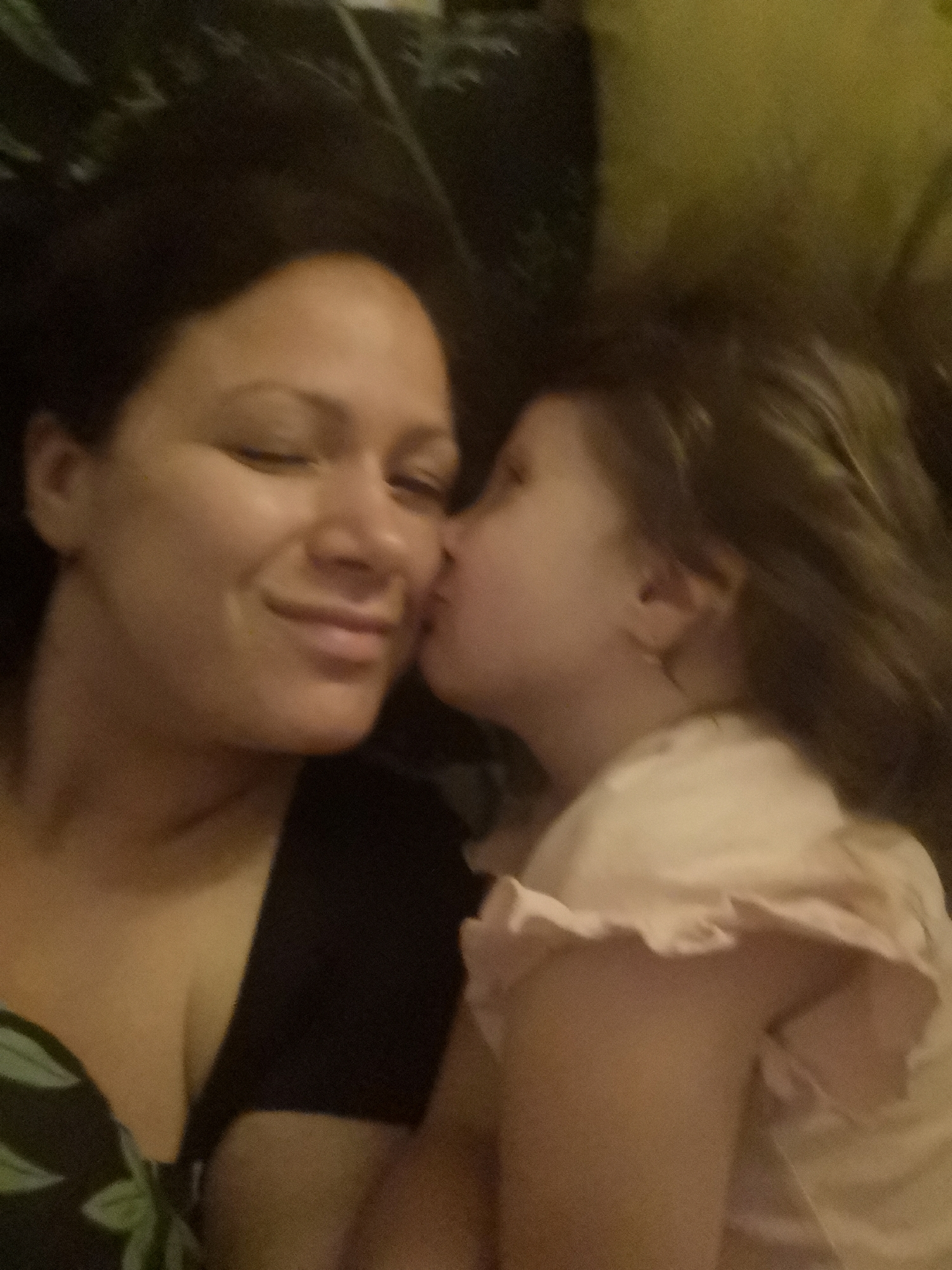 Mother and daughter share tender kiss moment