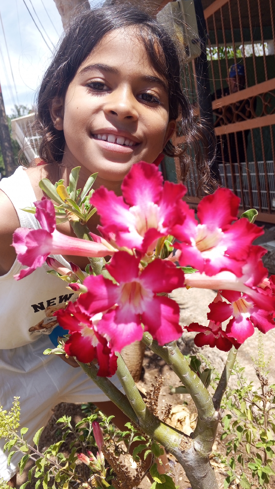 Young girl photographed among flowering plants and trees