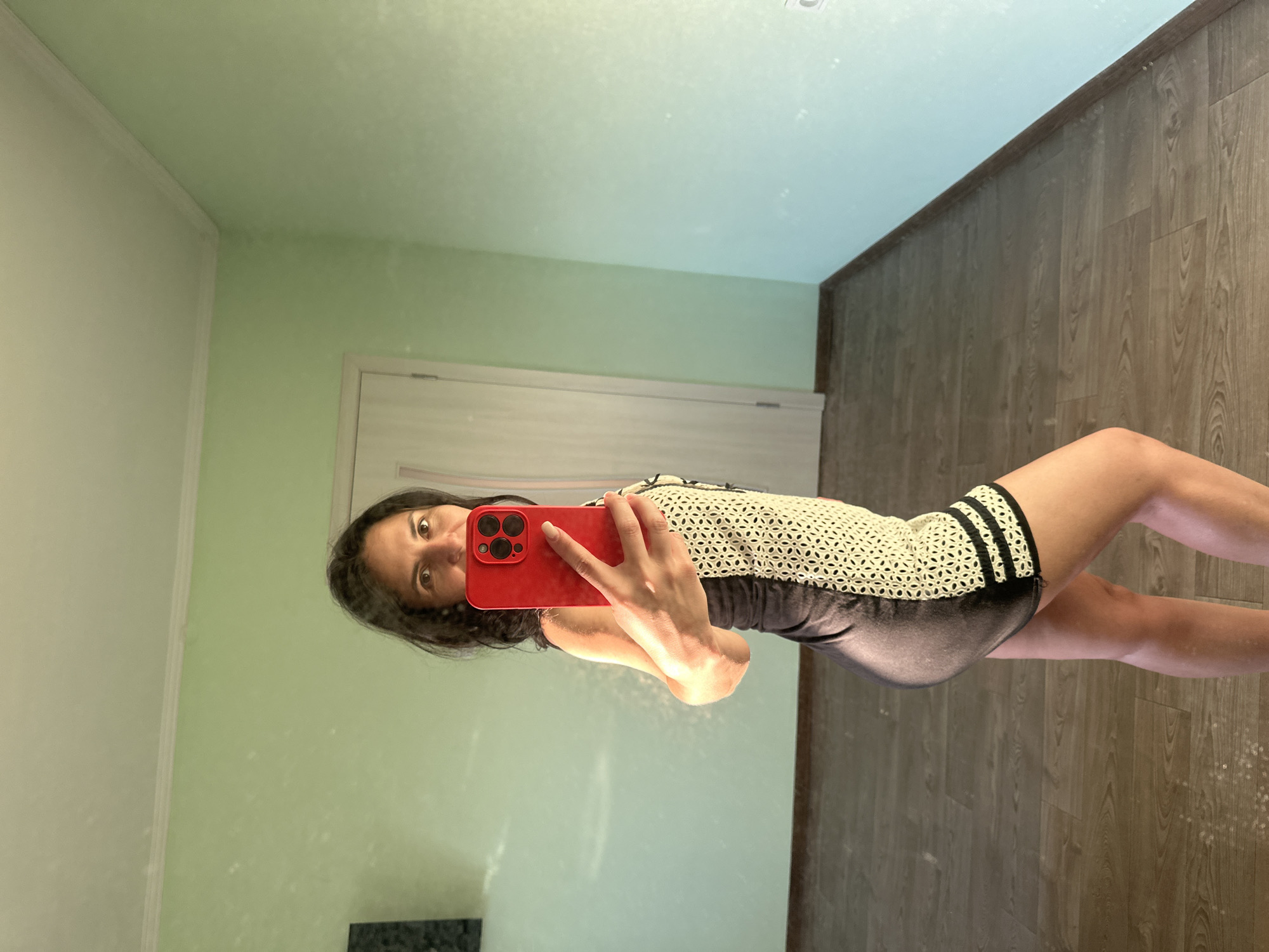 Mirror selfie session with a red phone, green-walled room
