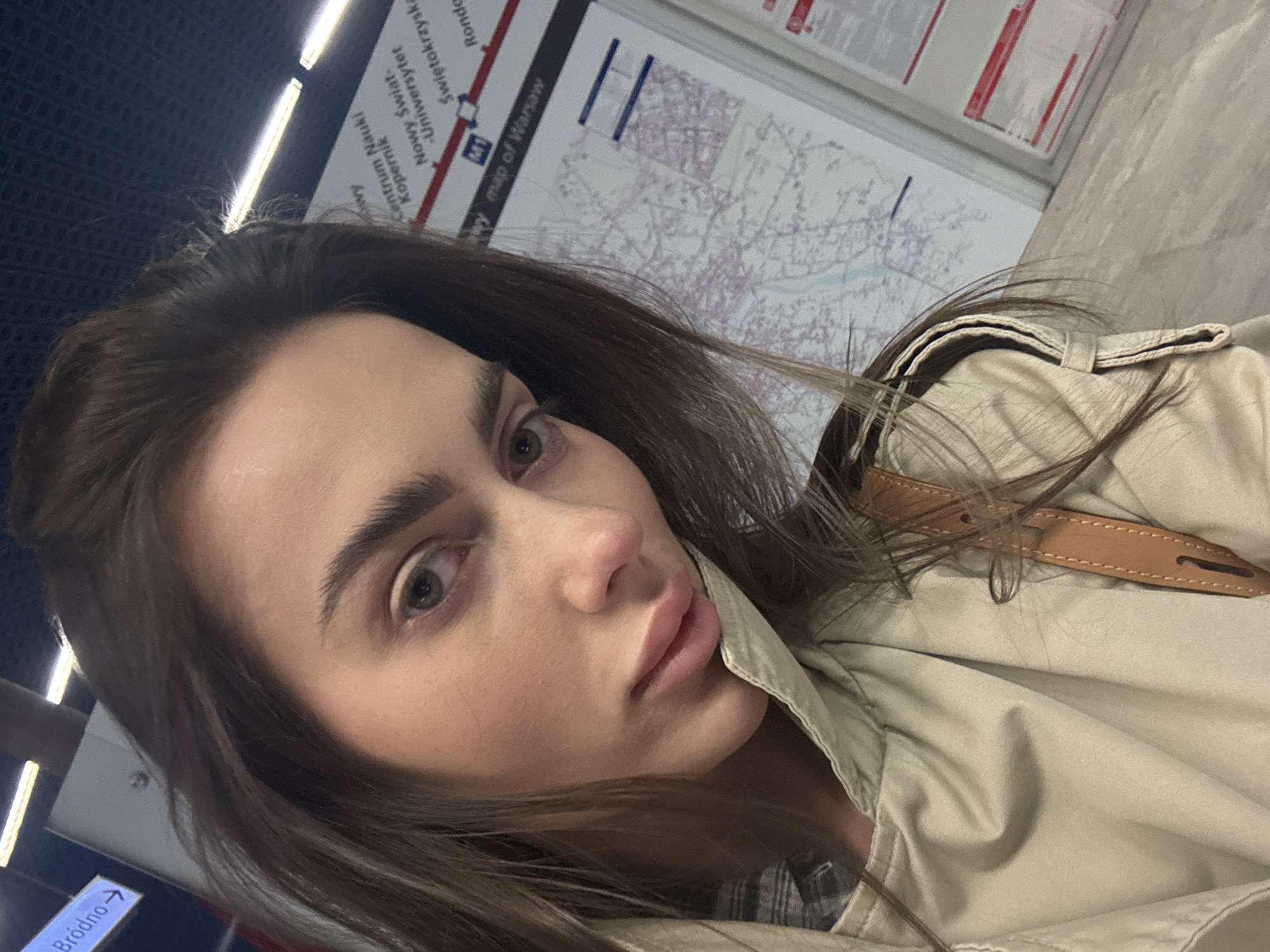 Woman takes selfie at Warsaw metro station as train arrives