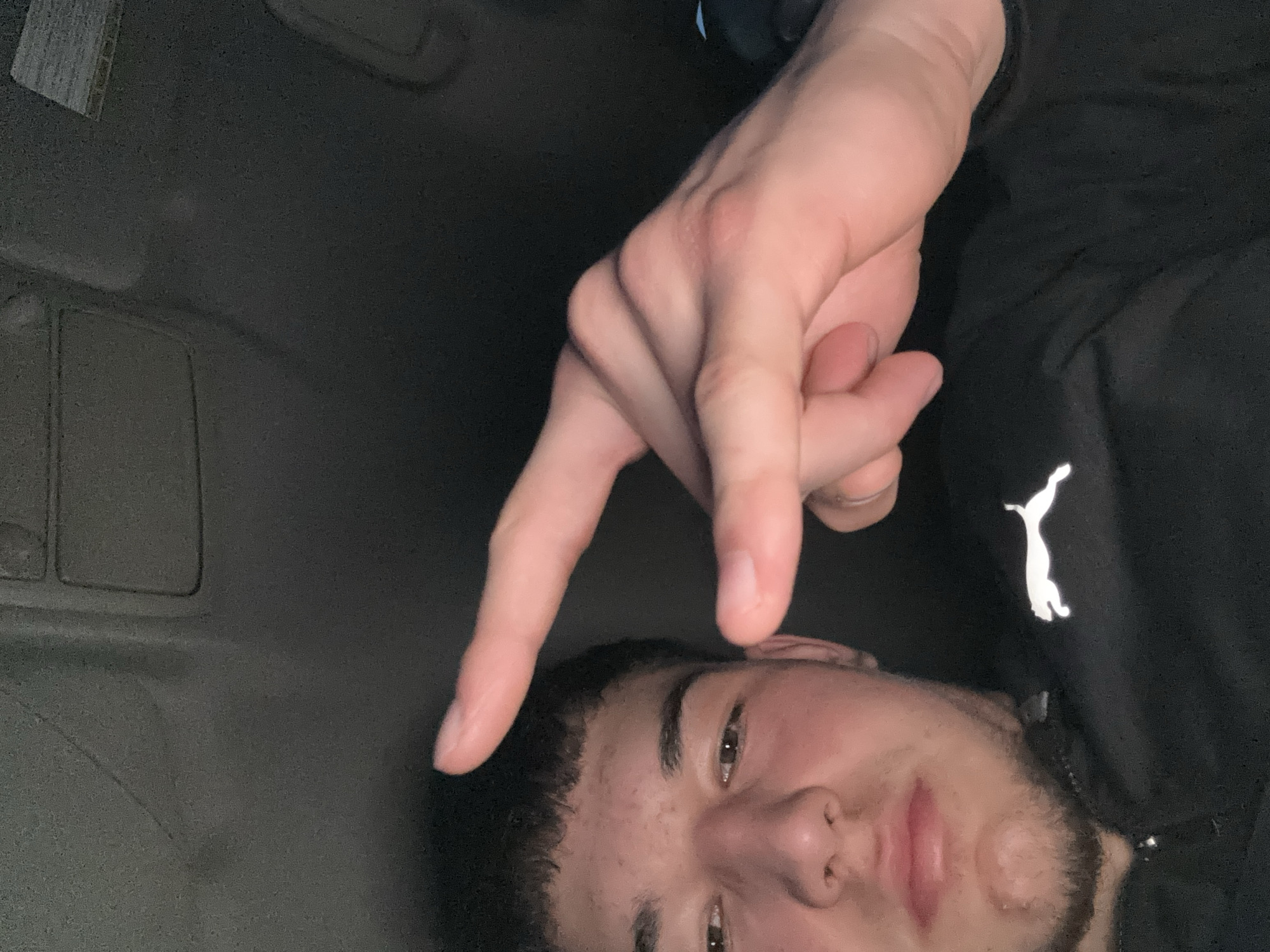 Person makes peace sign while resting in Honda car