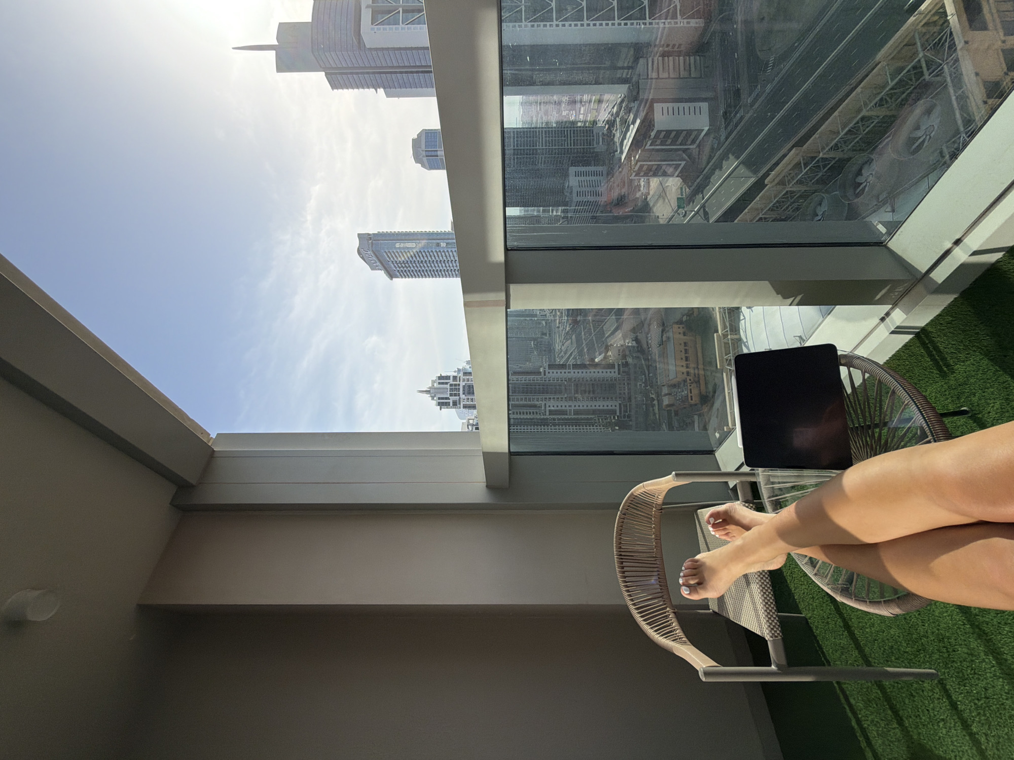 Person relaxes on high-rise balcony in Dubai Business Bay