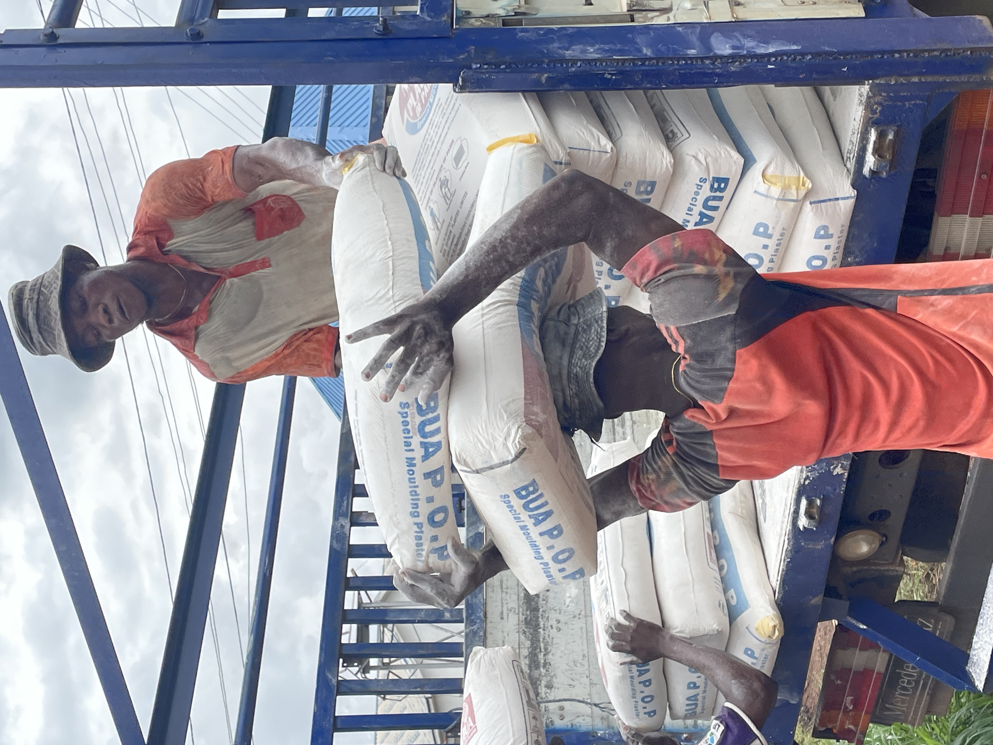 Construction materials being handled across an active Enugu supply site