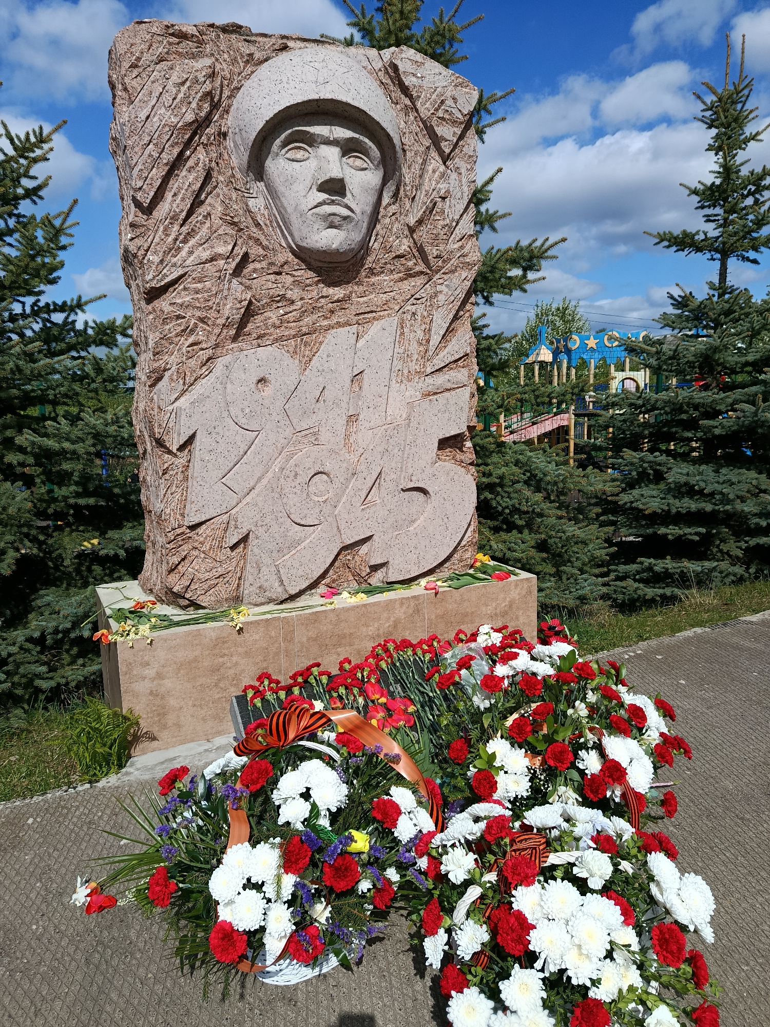 Family visits WWII memorial with flowers in Russian village