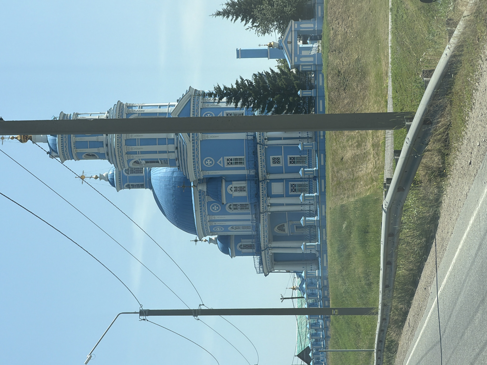 Blue and white Orthodox church with golden-crossed clock tower, Telma