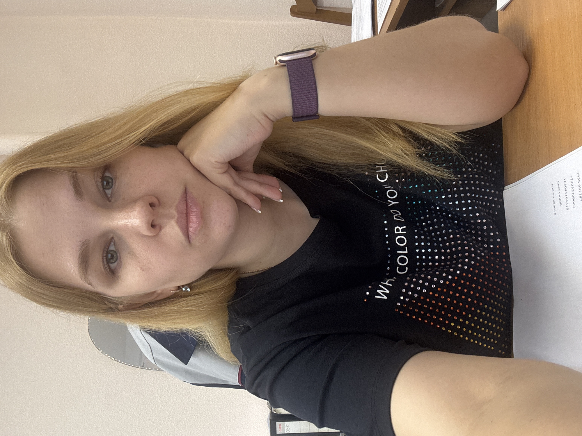 Woman rests in Rusanovo wearing colorful shirt, purple smartwatch