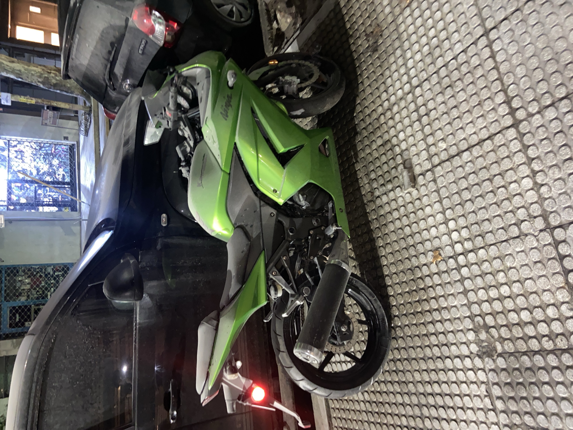 Motorcycle down on Buenos Aires walkway, entangled with vehicle