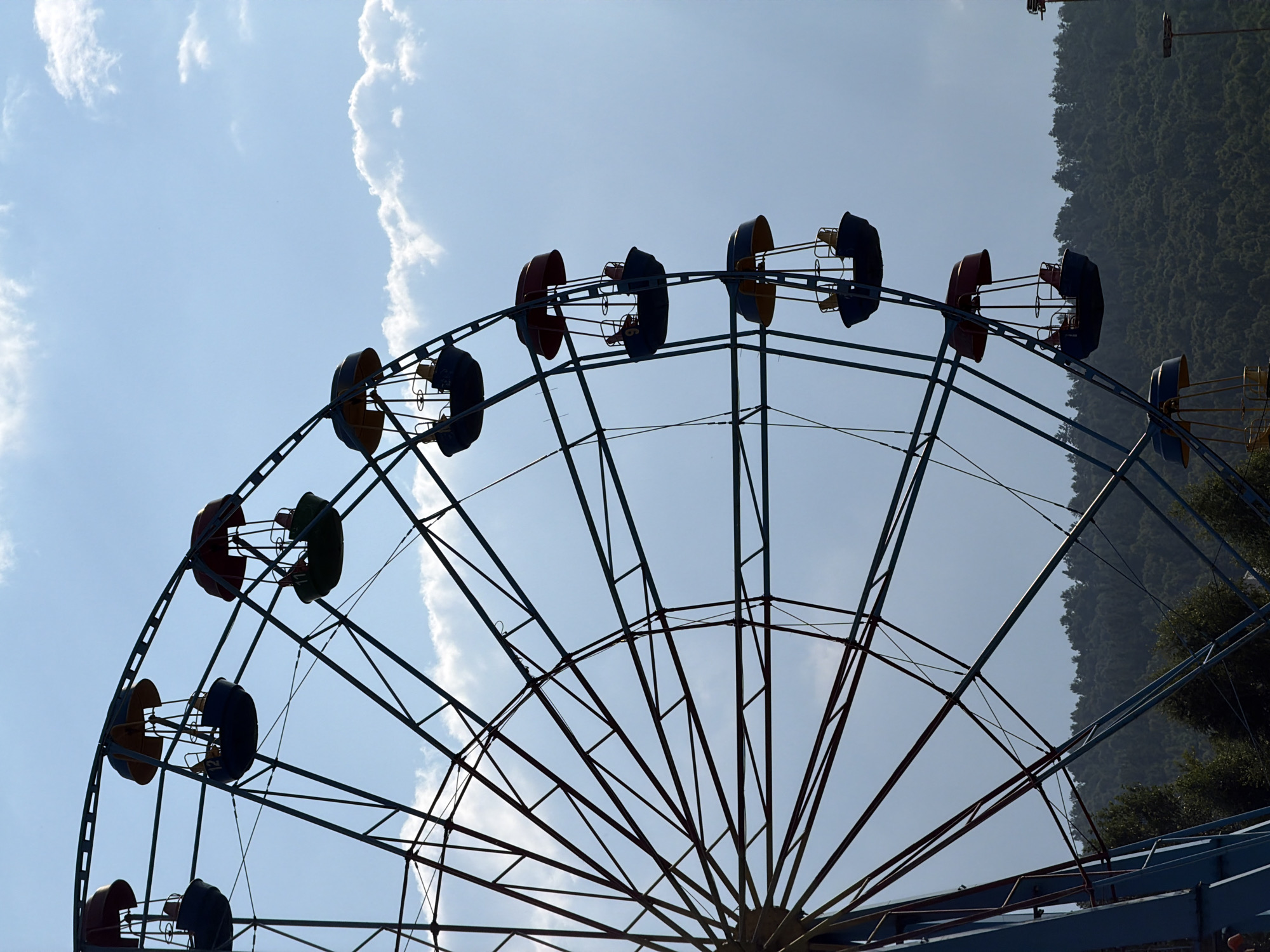 Ferris wheel and crepuscular rays fill an afternoon