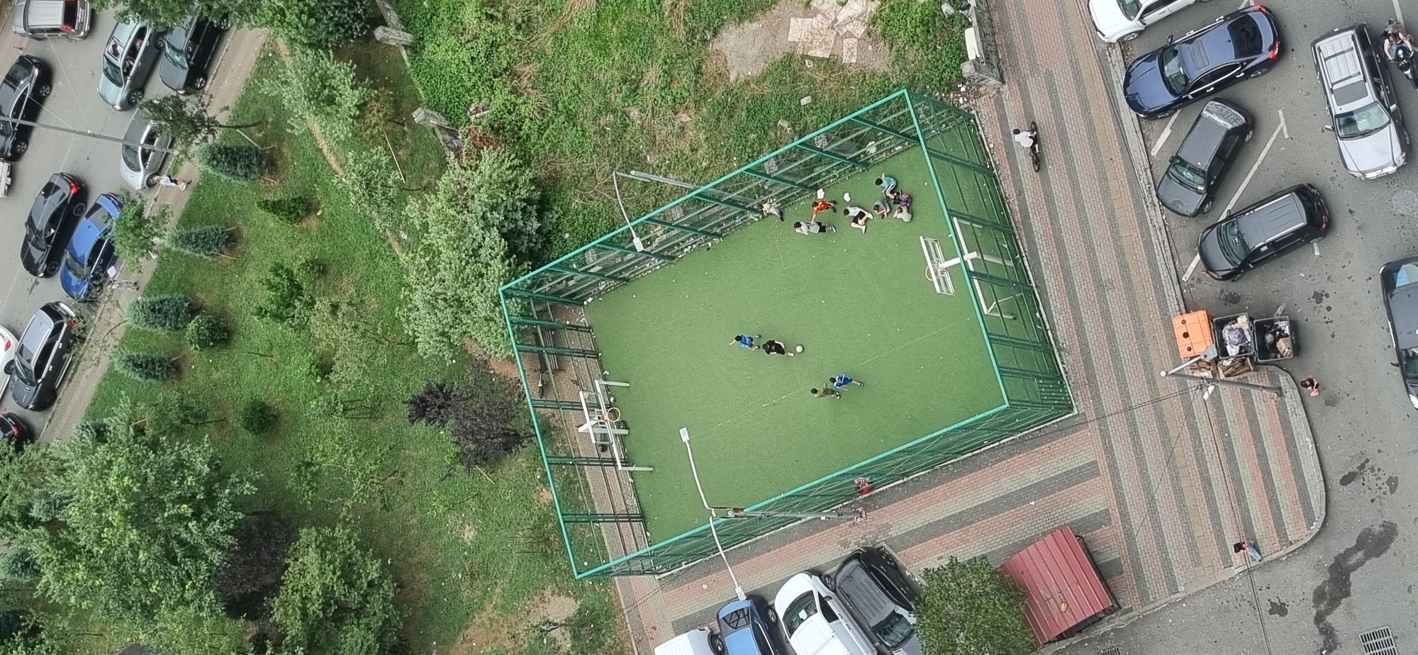 Midday aerial sweep of Batumi streets, intersections, and a soccer court
