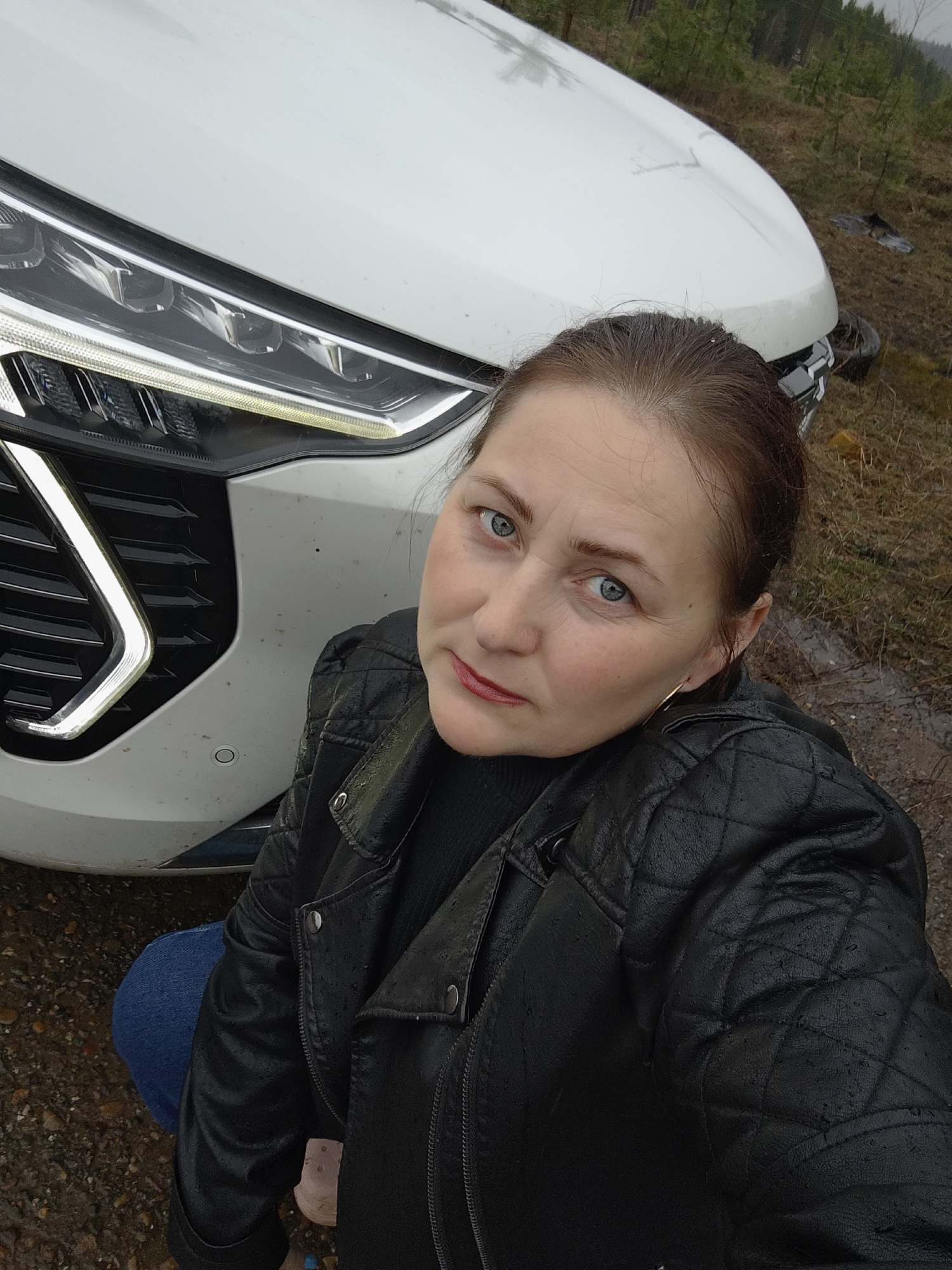Woman takes outdoor selfies near car in Chaikovsky, Russia
