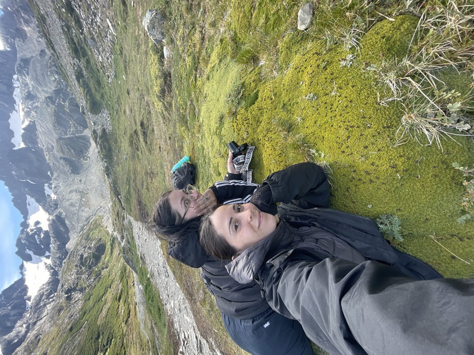 Women rest on mossy mountainside during Ushuaia hiking trip