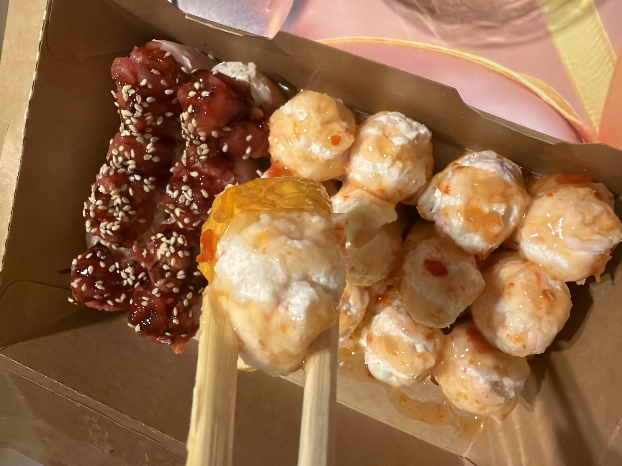Person eats takeout meal with chopsticks from compartmented container