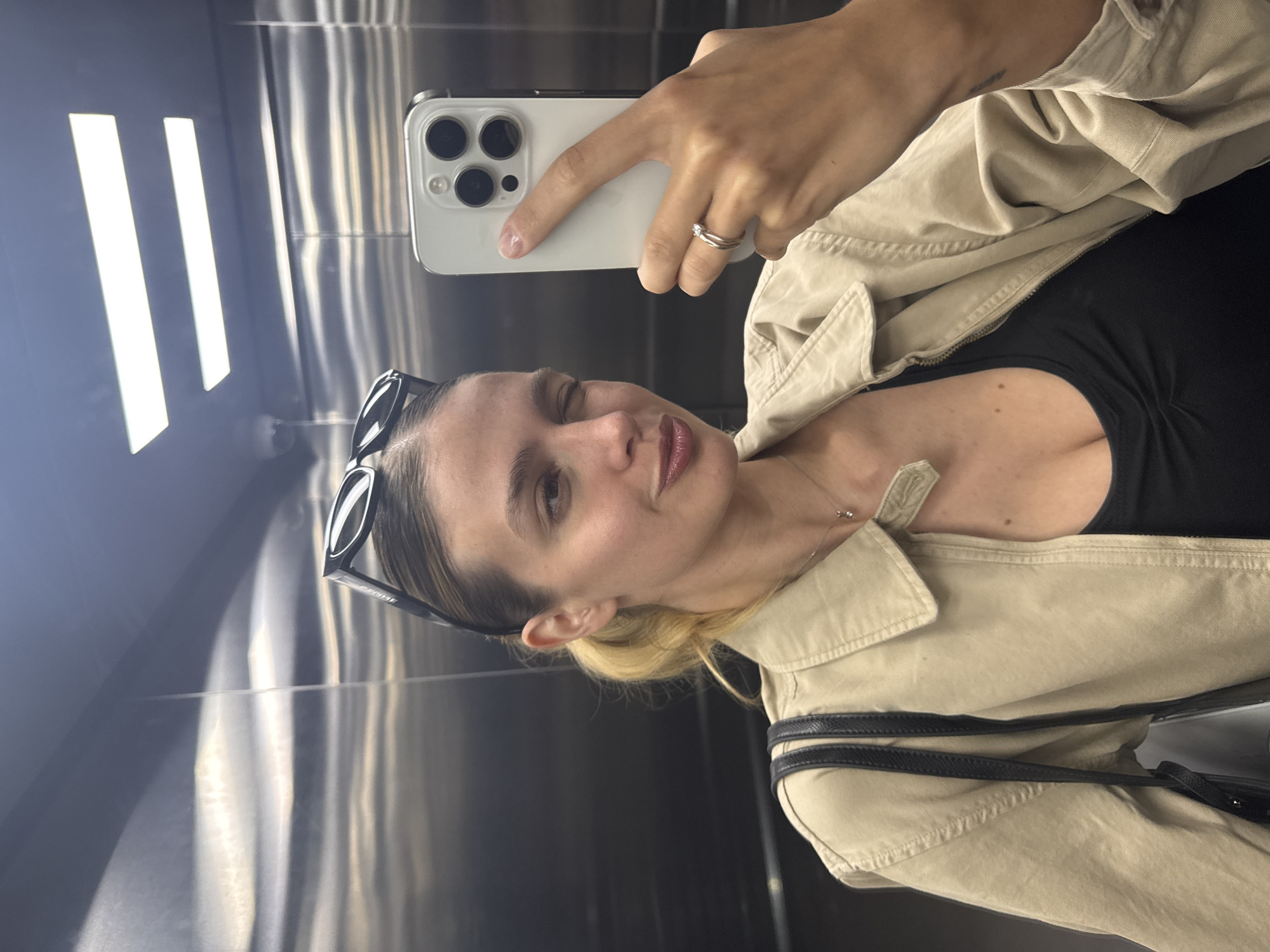Woman takes elevator selfie with smartphone
