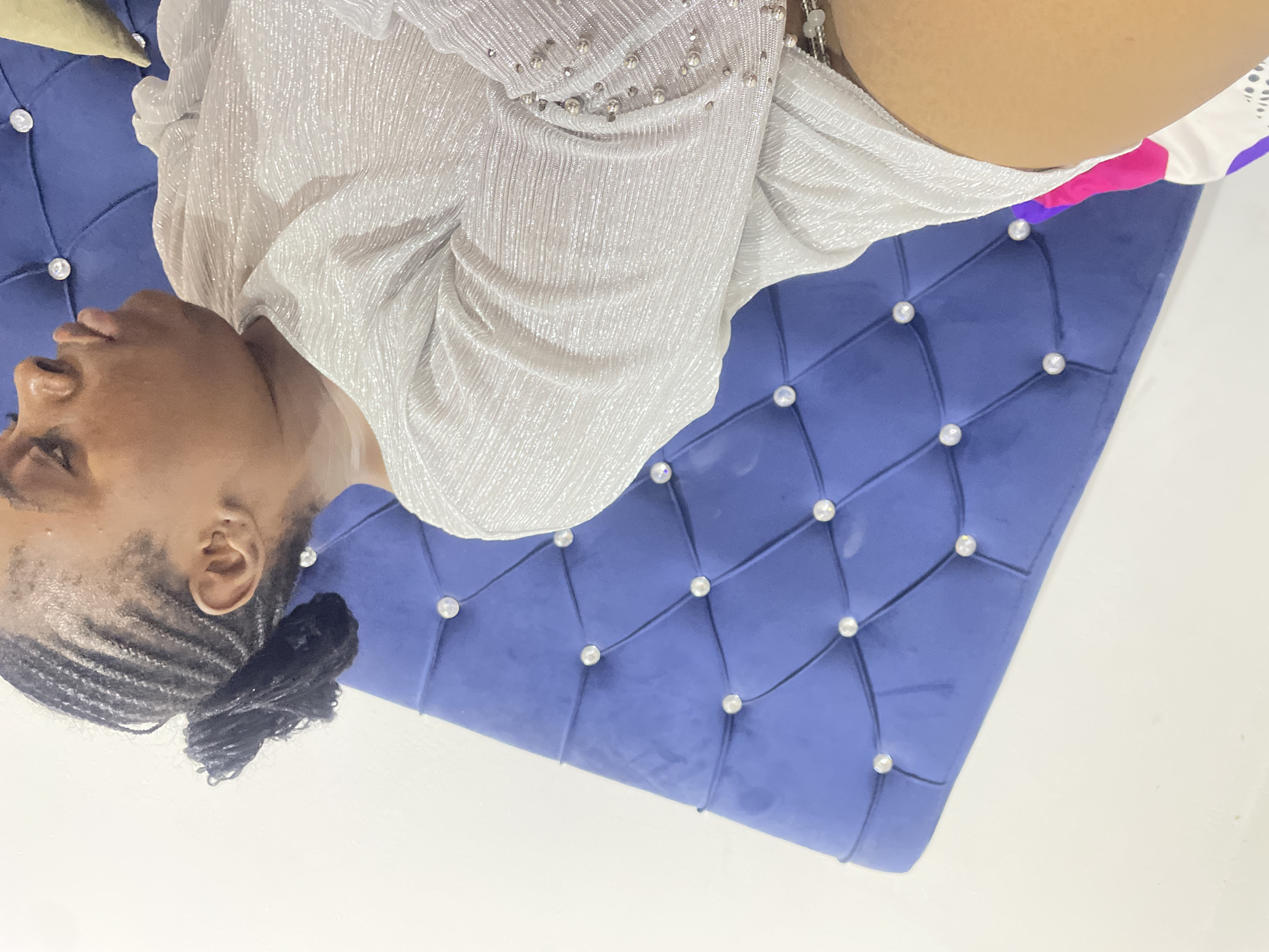 Woman observed sitting on blue couch in Abuja indoor setting