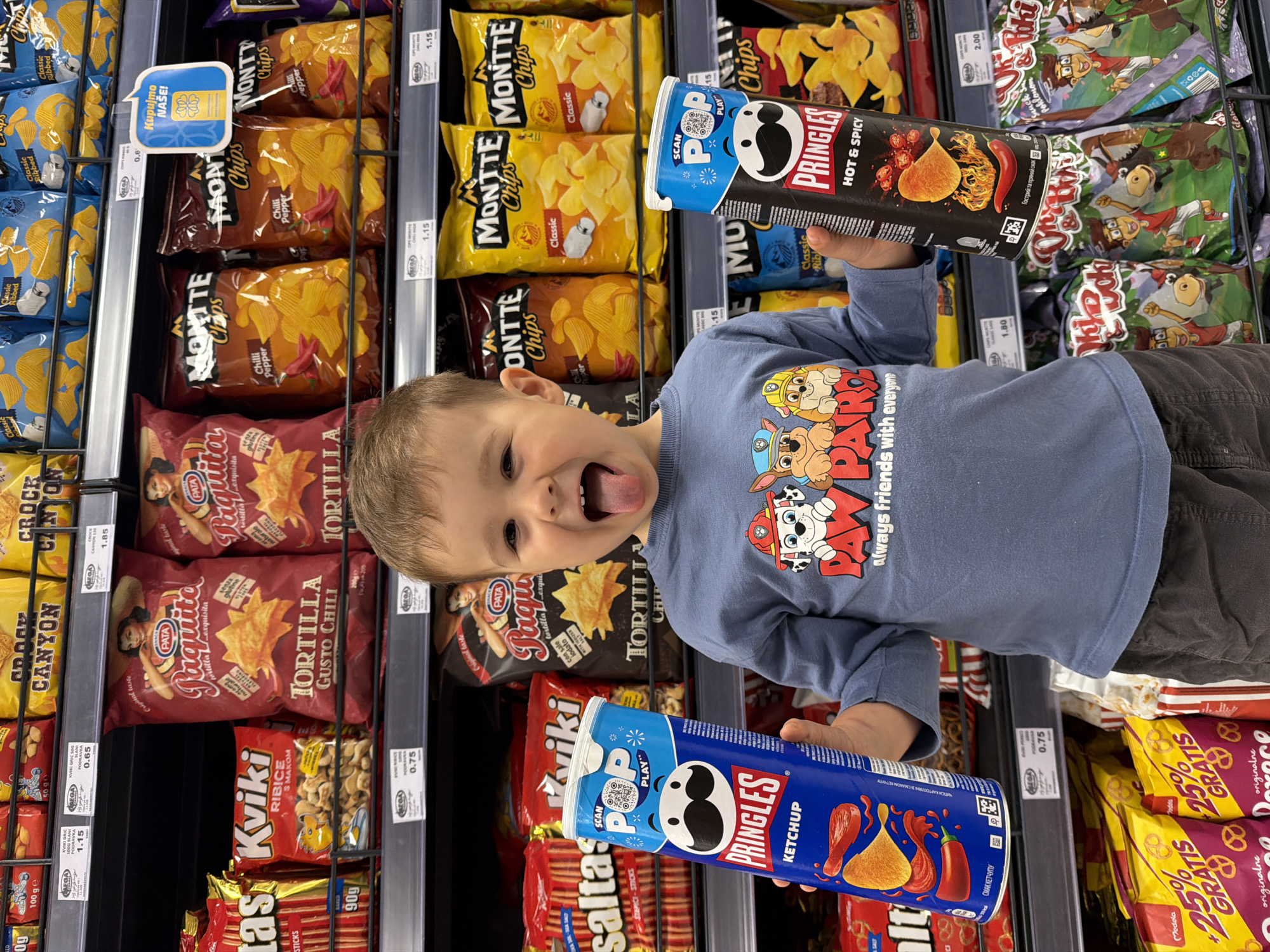 Boy shops playfully in Montenegro supermarket wearing Paw Patrol shirt