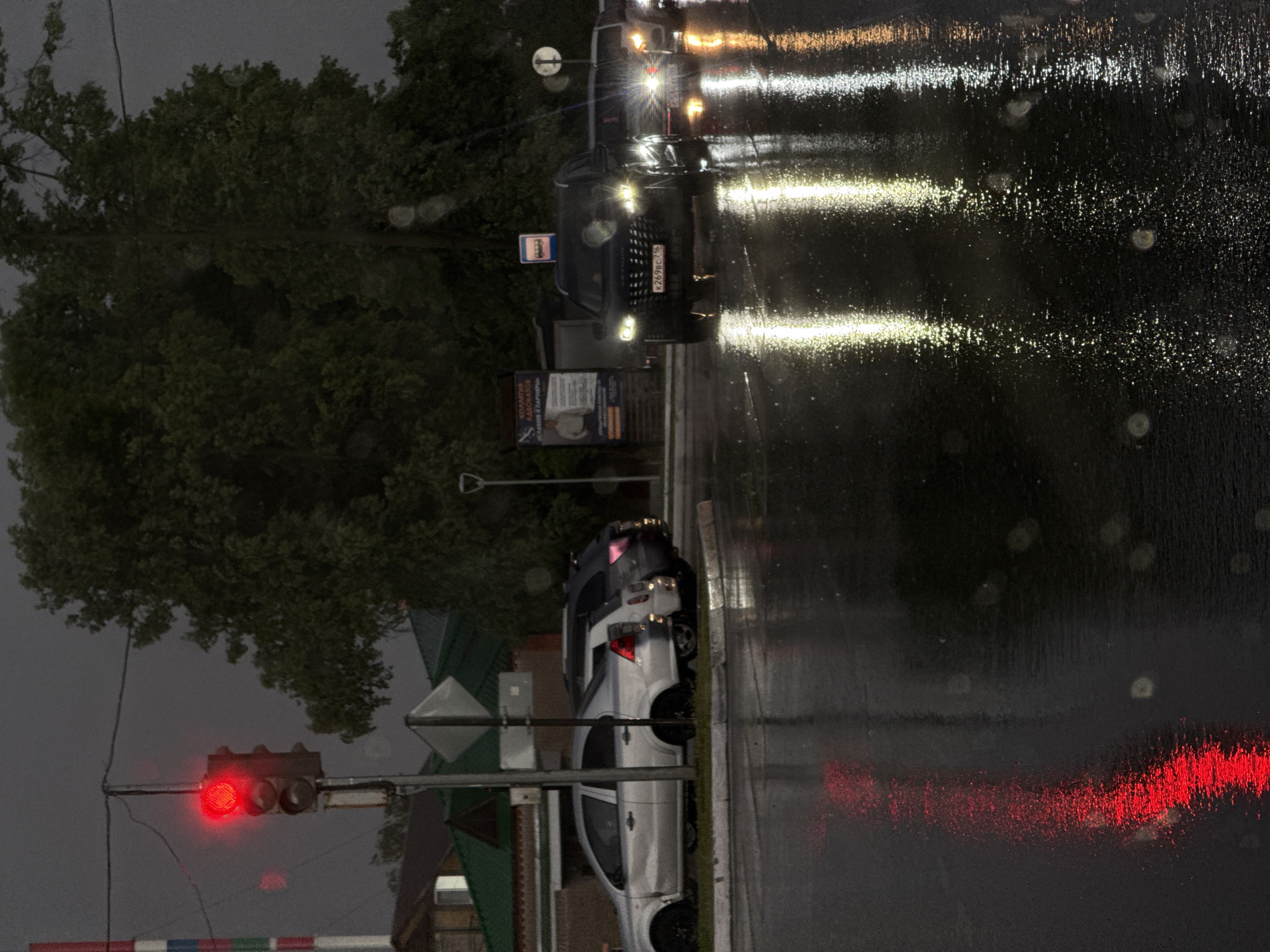 Rainy evening traffic observed at railroad crossing in Agryz, Russia
