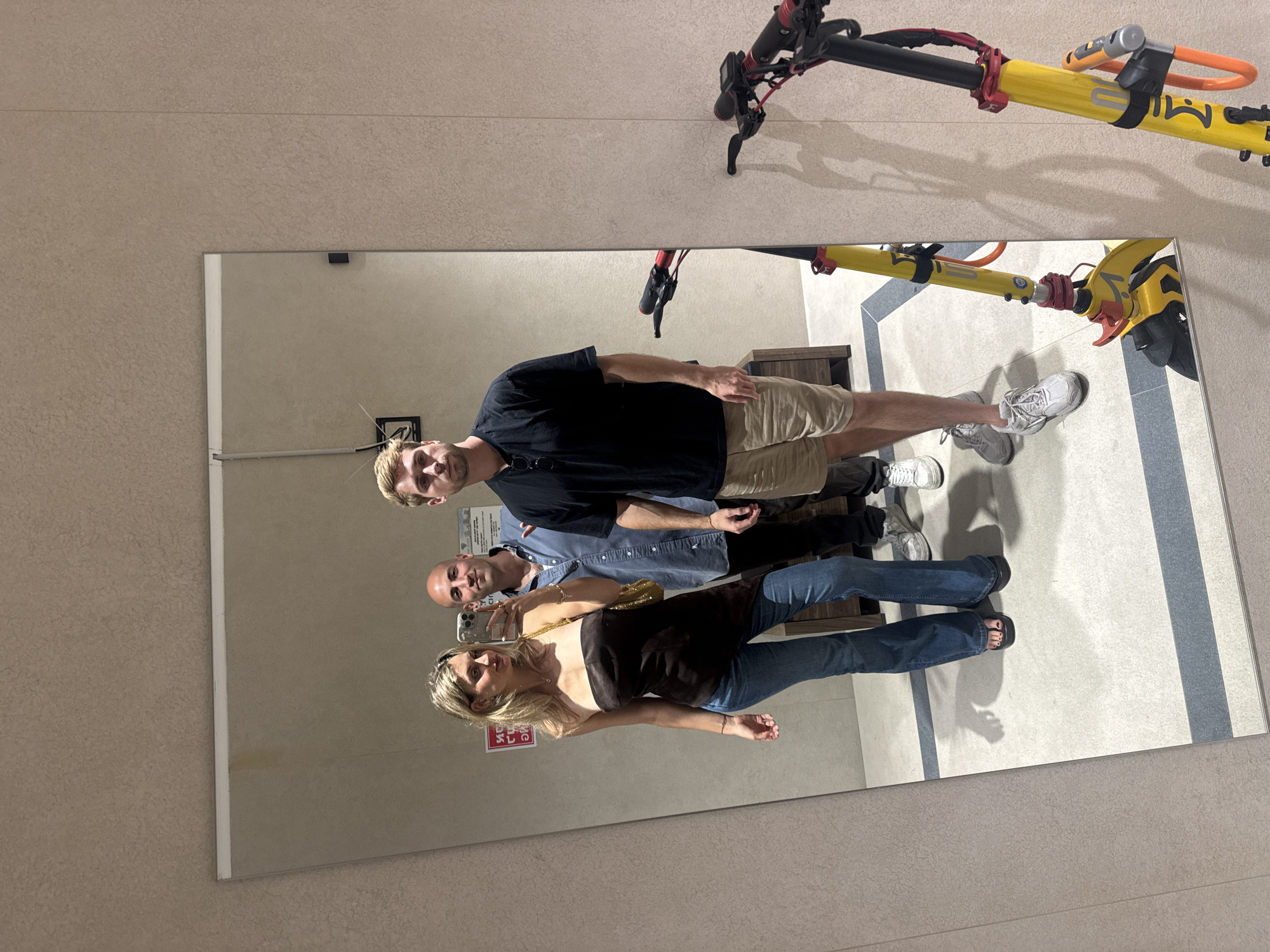 Three people take mirror selfie in Tel Aviv indoor location