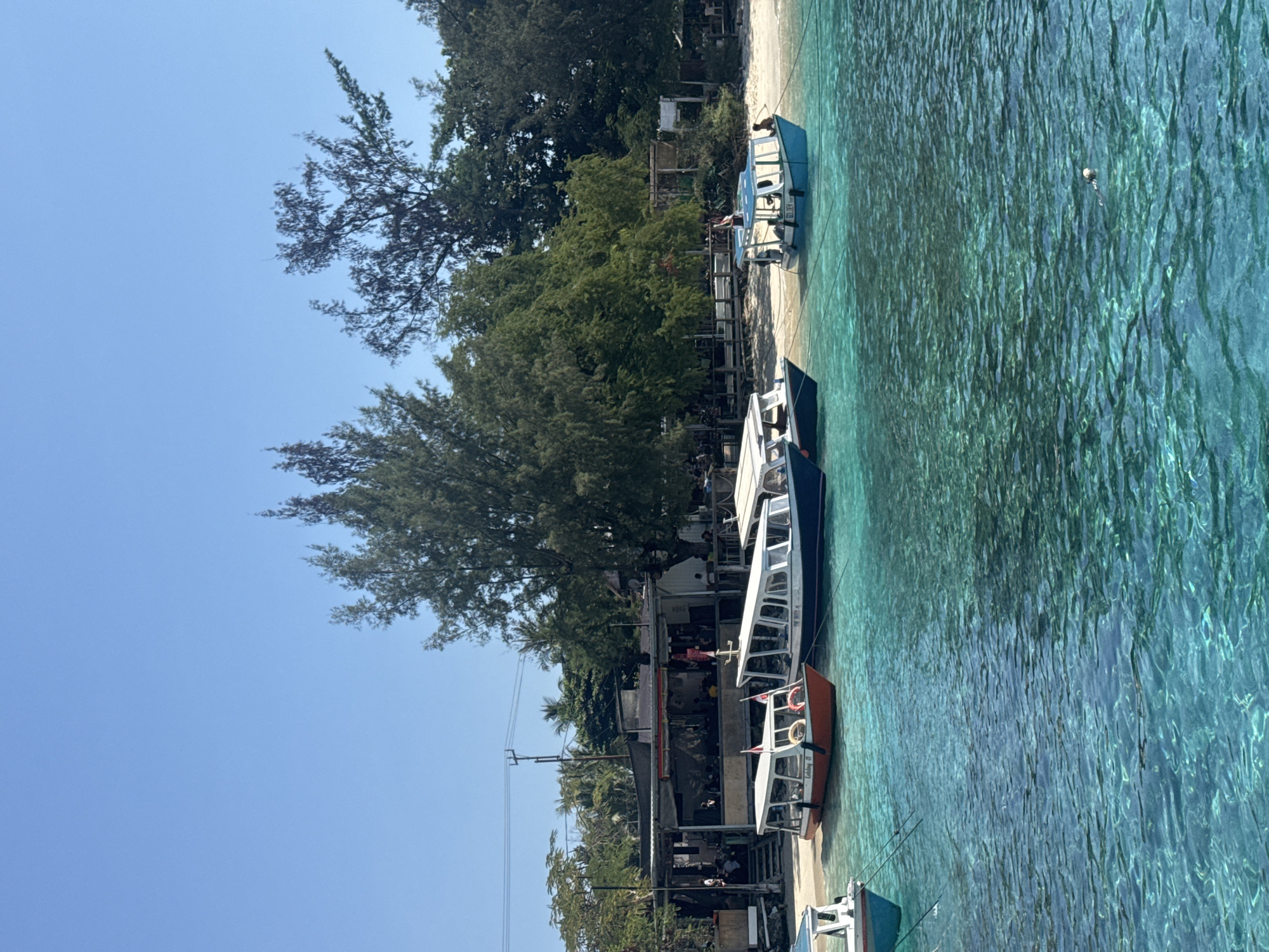 Boats and clear water at a sunny Indonesian harbor