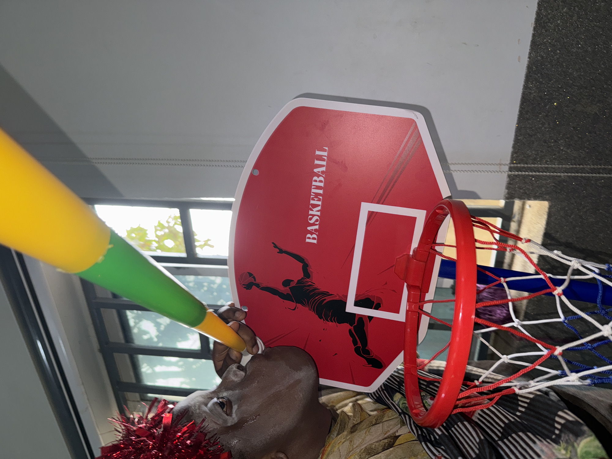 Person with face paint, crown poses under basketball hoop