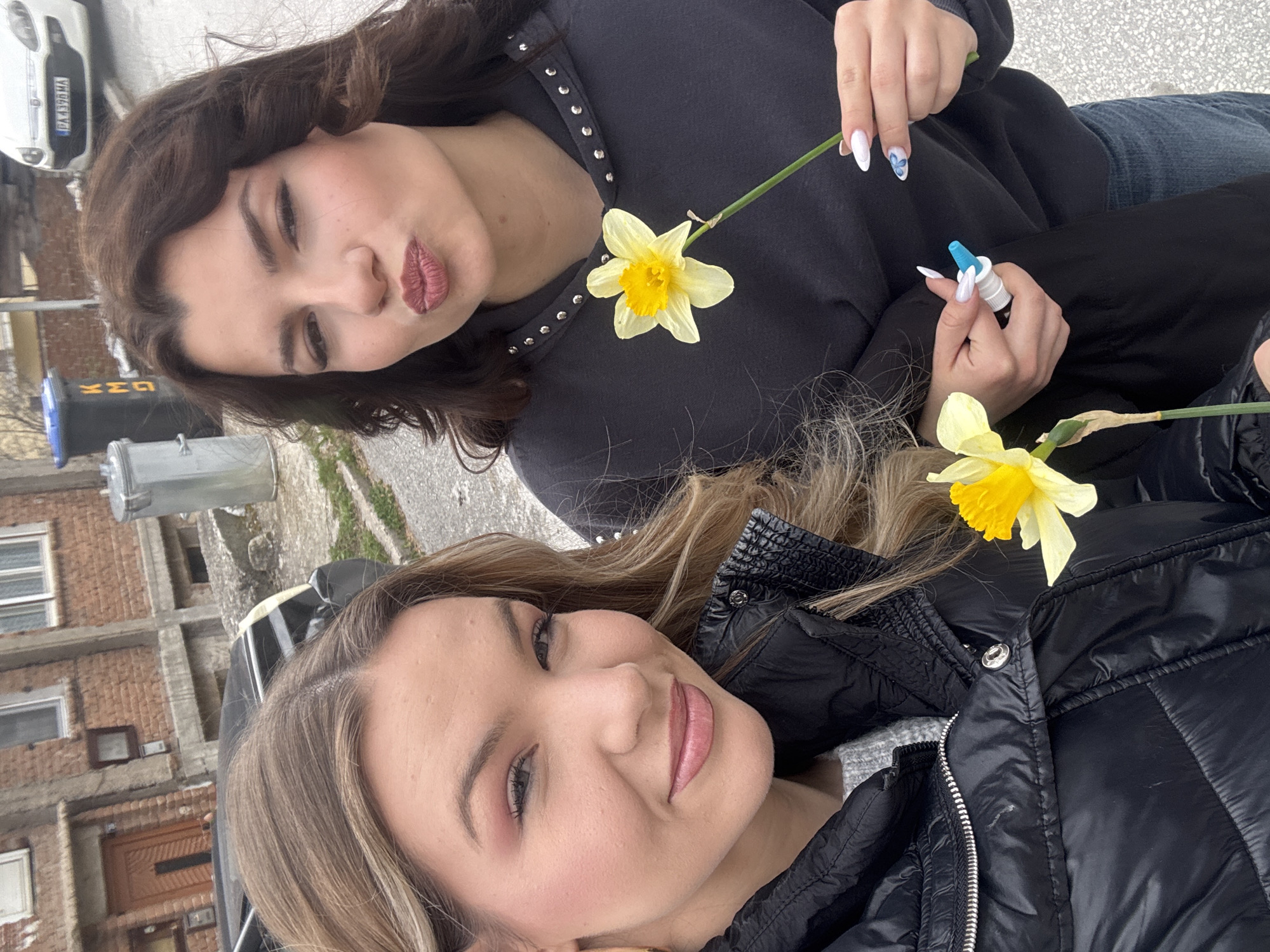 Two women pose with daffodils for selfie in Velingrad