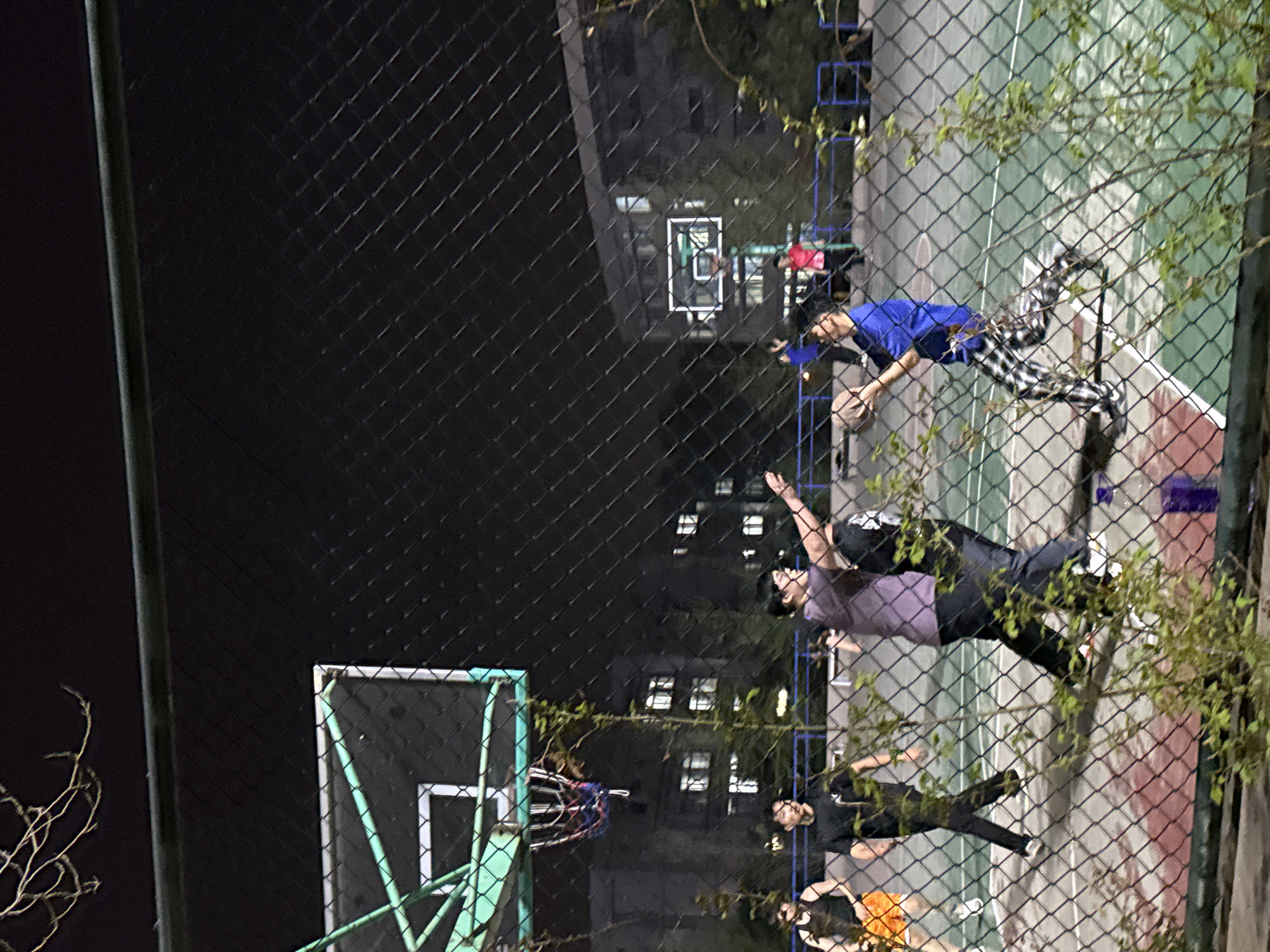 Nighttime basketball game observed at Zhongtun court