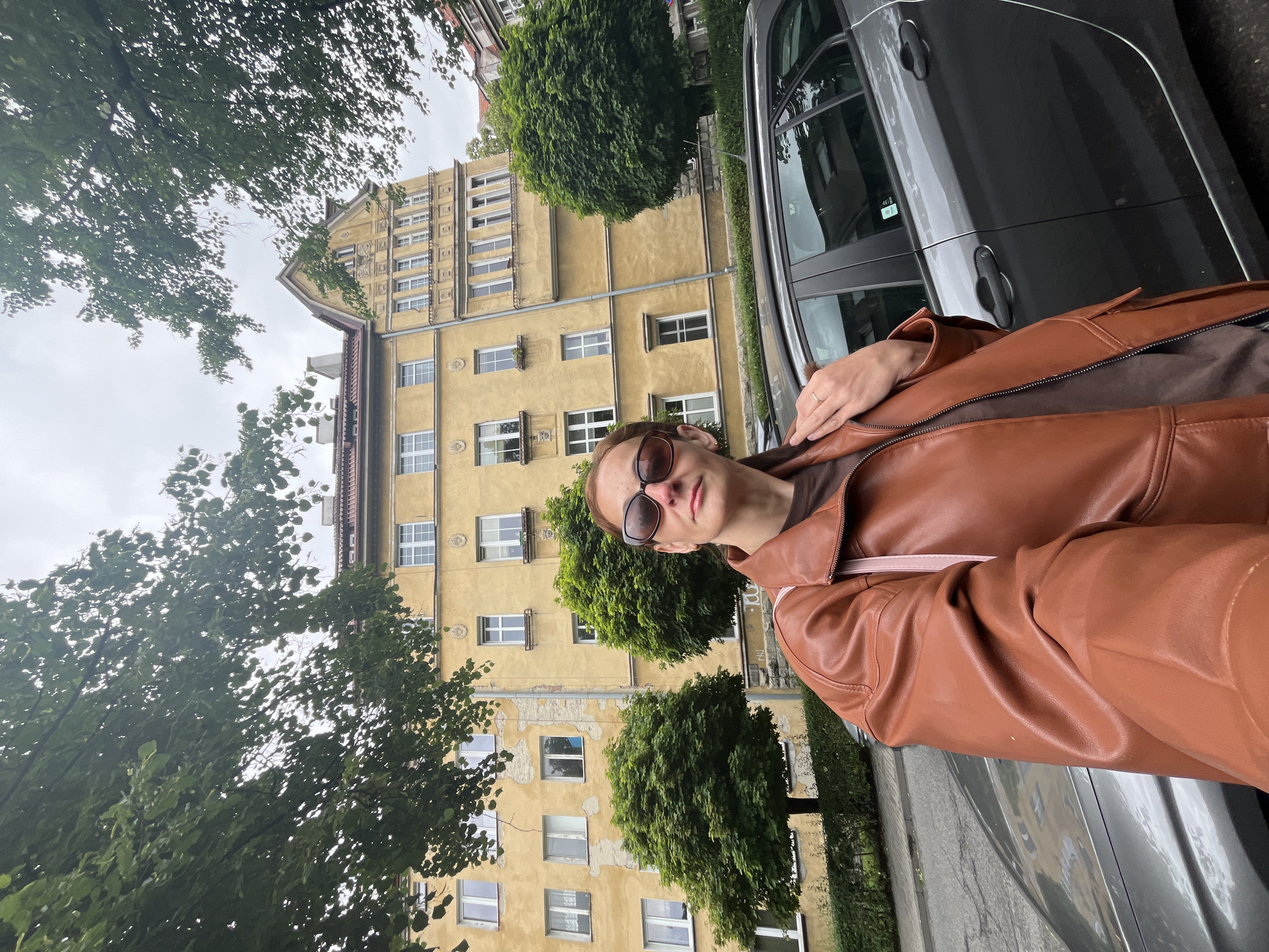 Woman in Brown Jacket Takes Selfies Across City