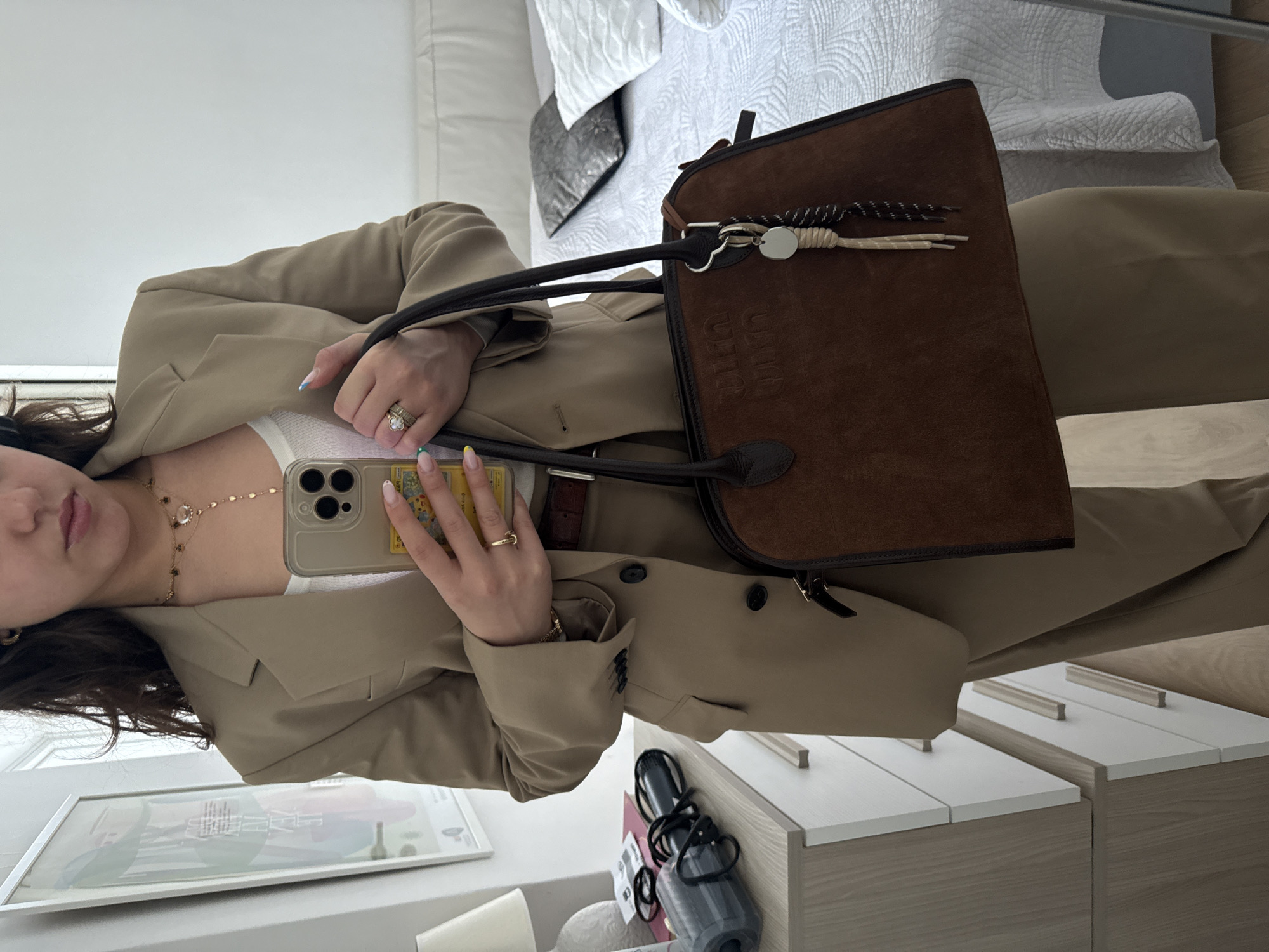 Woman takes mirror selfies in beige blazer, Milan morning