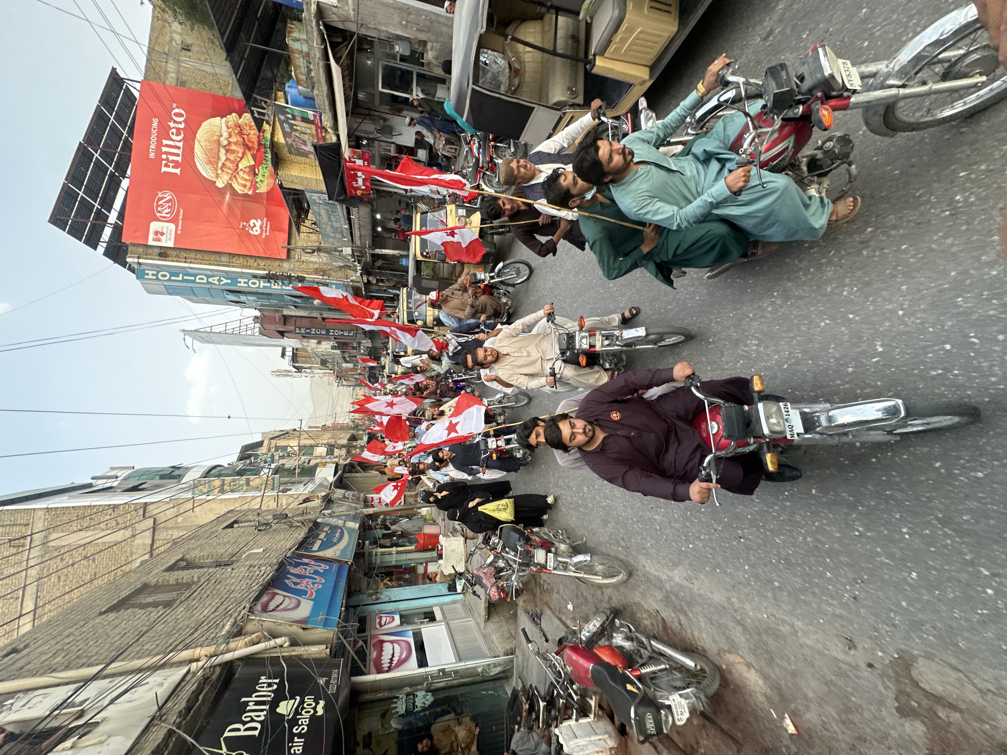 Flag-bearing procession rolls through Quetta's busy commercial streets