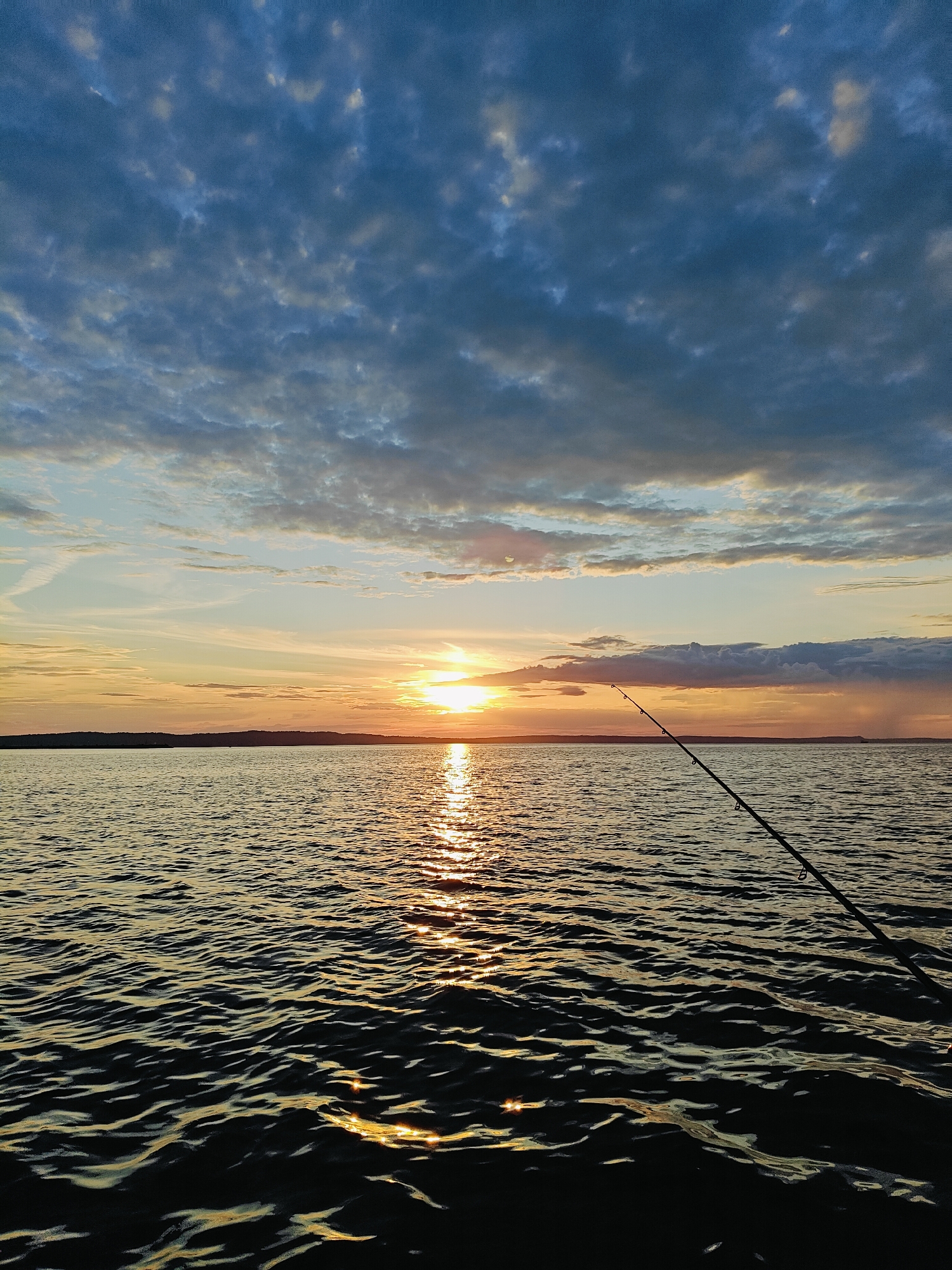 Fishing at sunset on a calm Chaykovsky waterway
