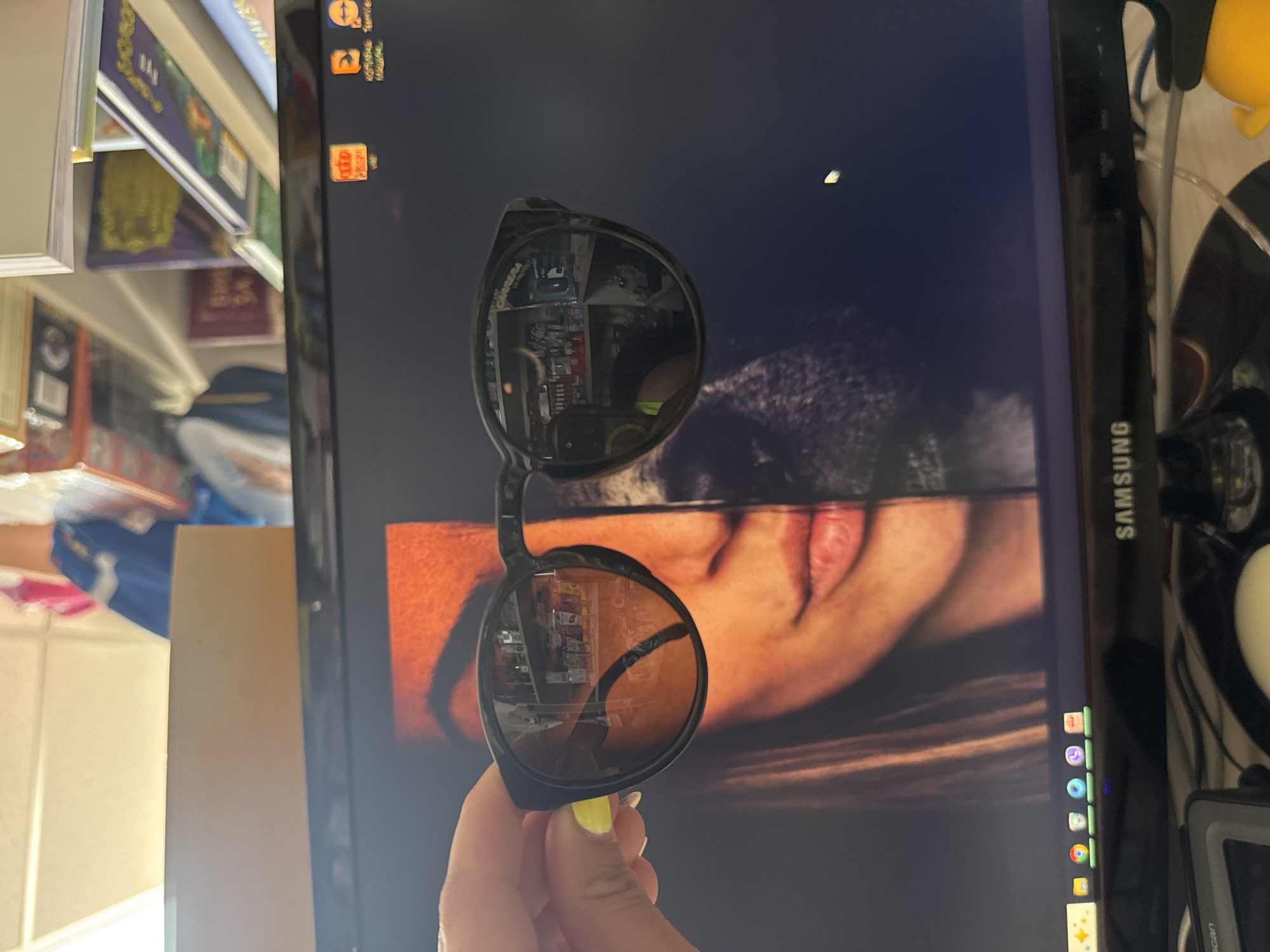 Sunglasses held up to a split-screen monitor at a Bulgaria desk