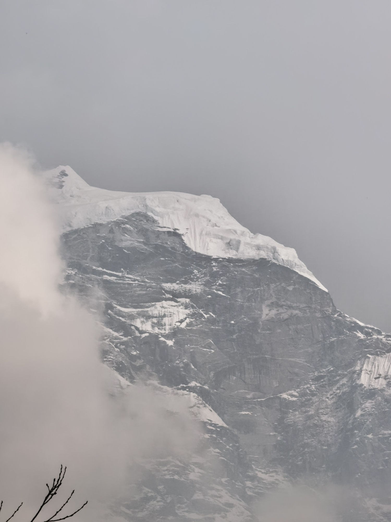 Snow-capped peak photographed through clouds in Deboche, Nepal