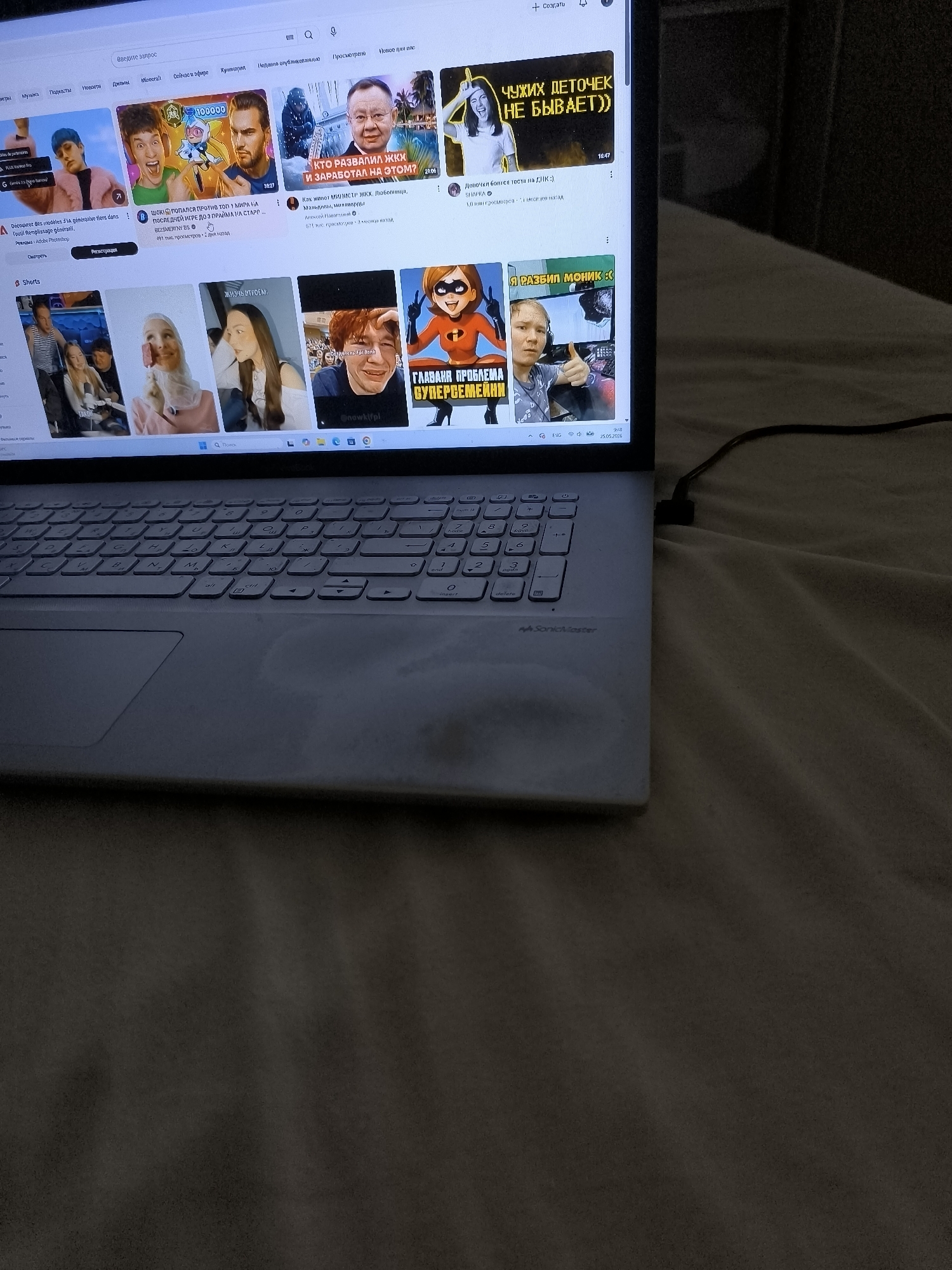 Person browsing Russian YouTube on laptop in French bedroom