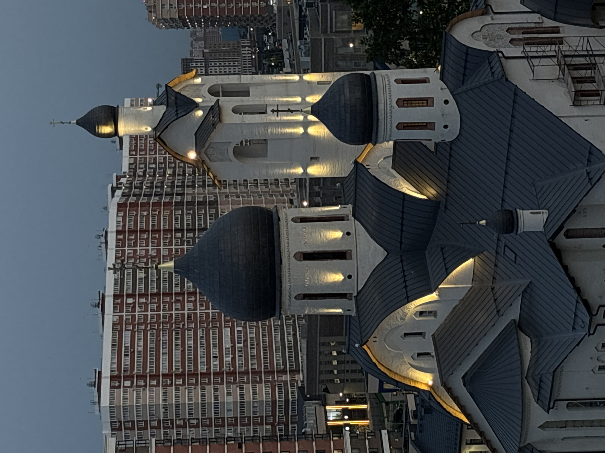 Orthodox church glows at dusk amid Krasnodar's urban skyline