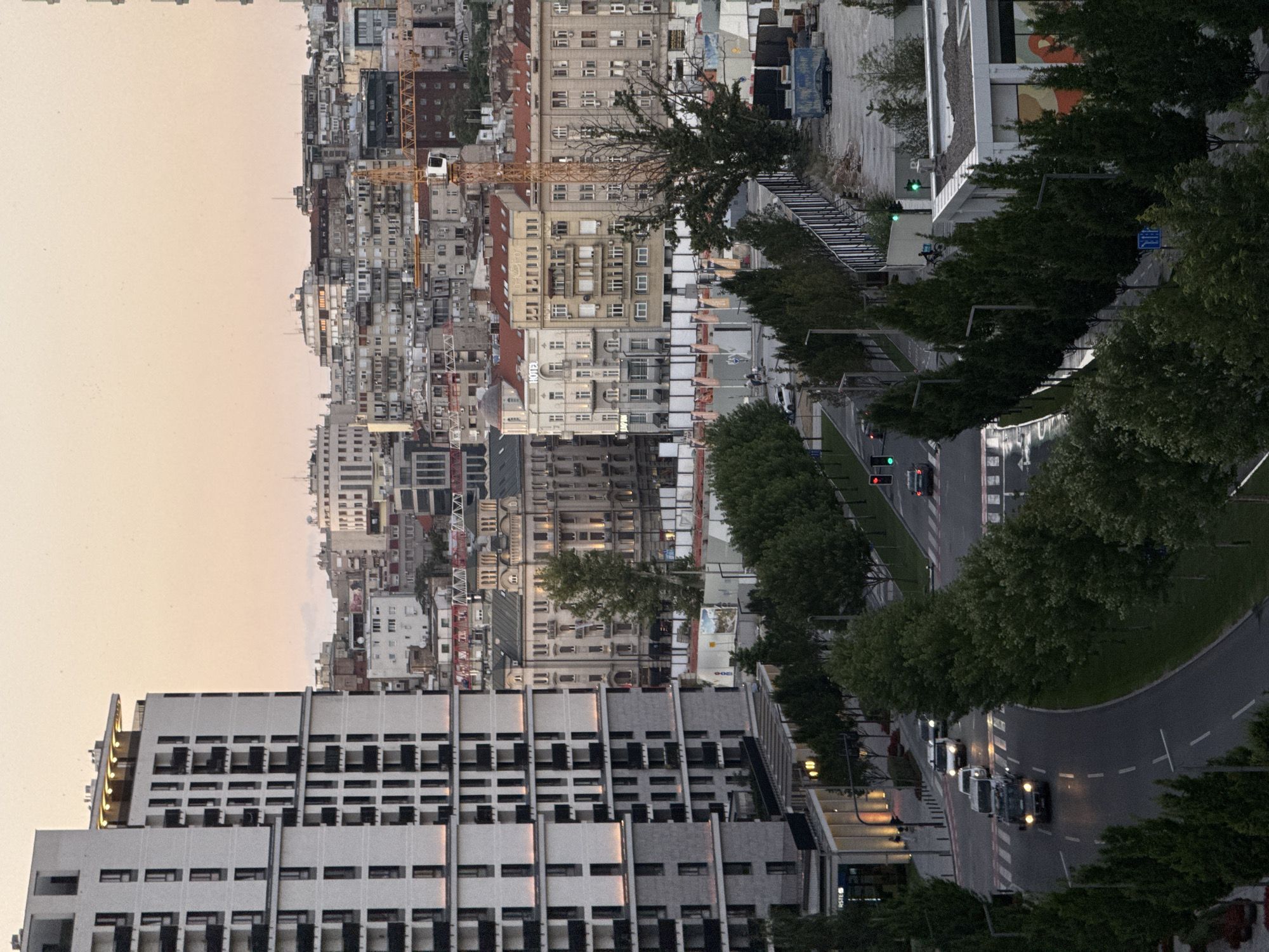 Belgrade skyline at dusk: modern towers, cranes, and colorful bird sculptures