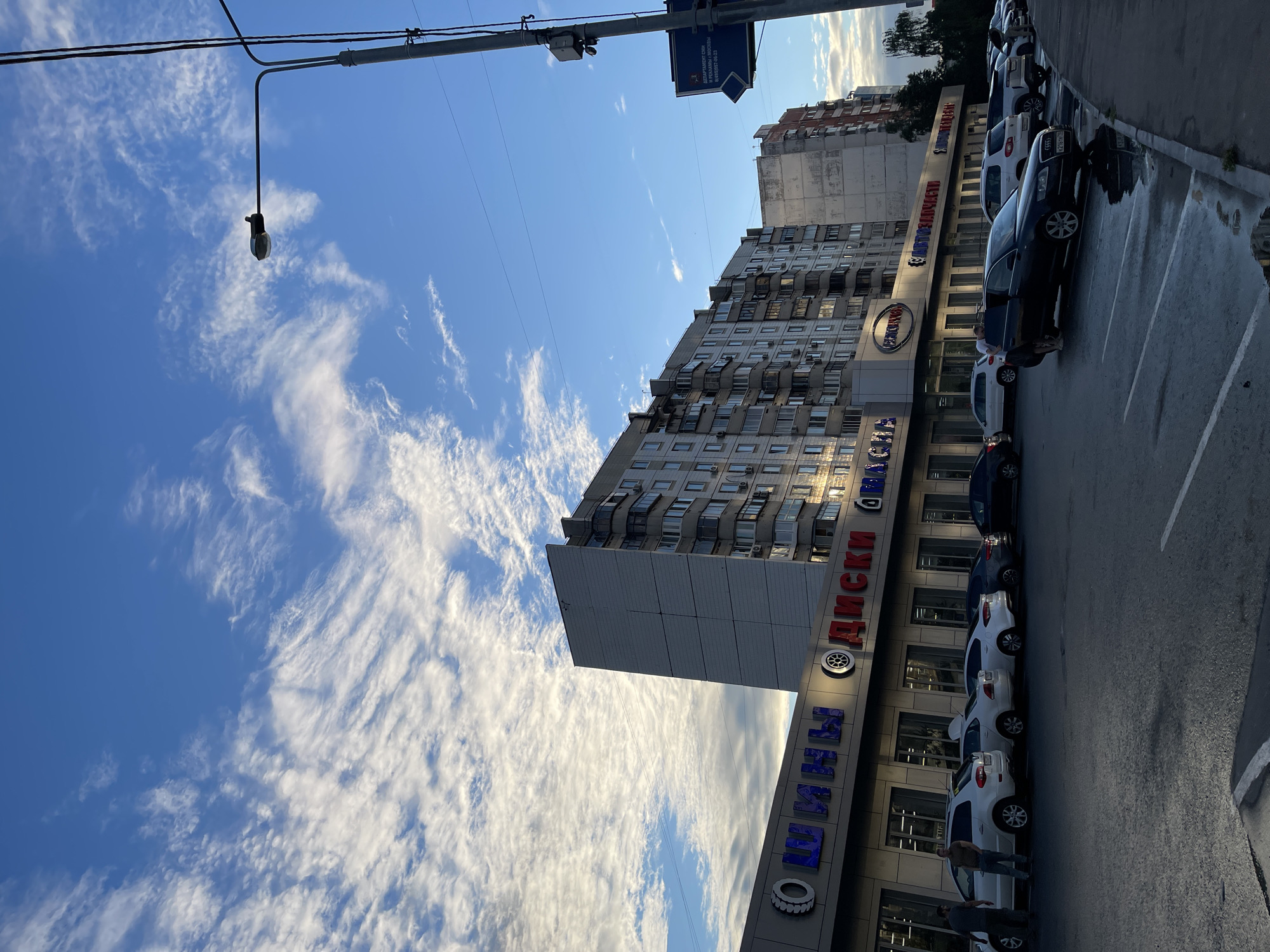 Moscow side street, auto shops and apartment blocks on a June afternoon