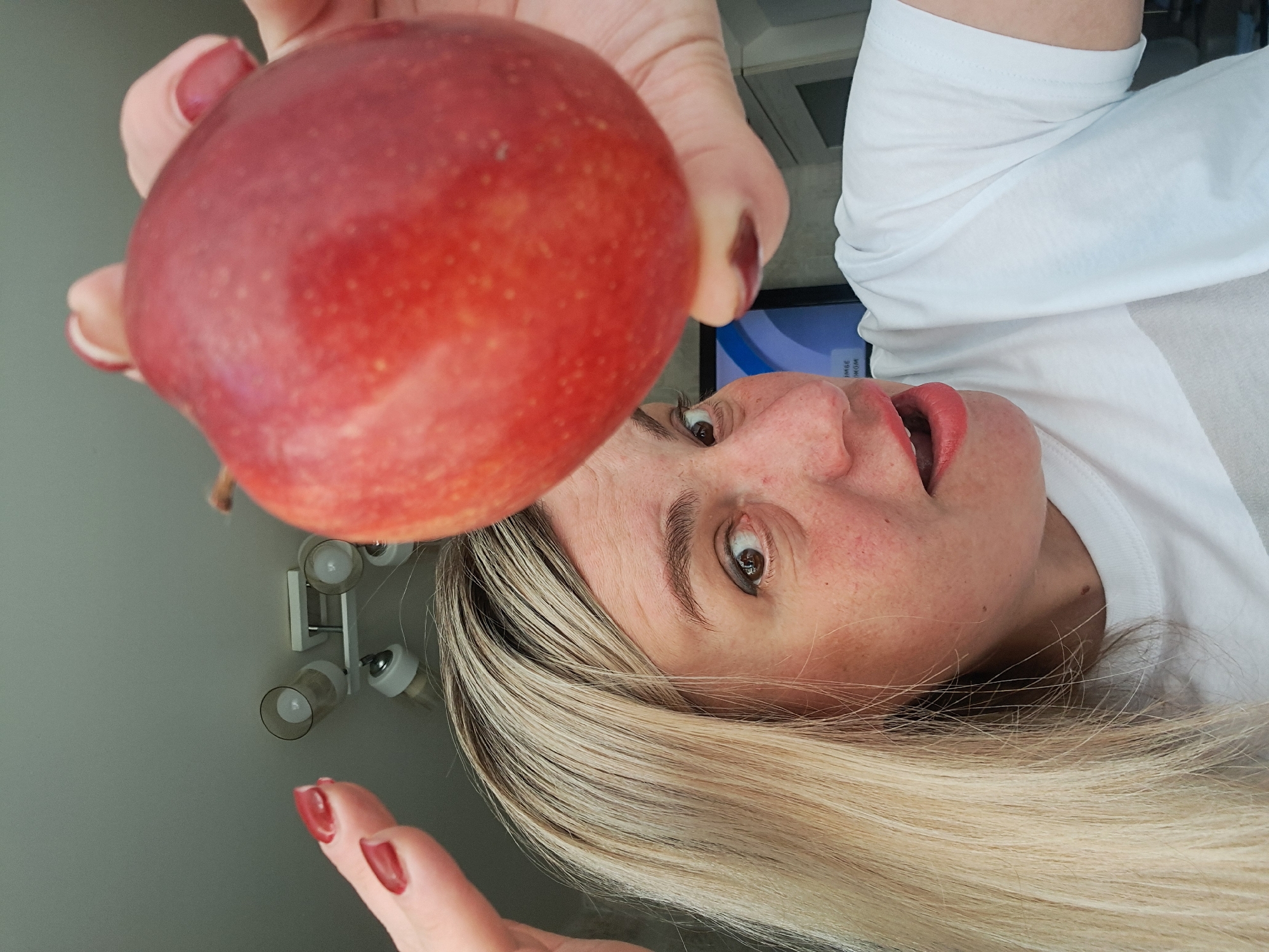 Woman displays red apple to camera in Russia