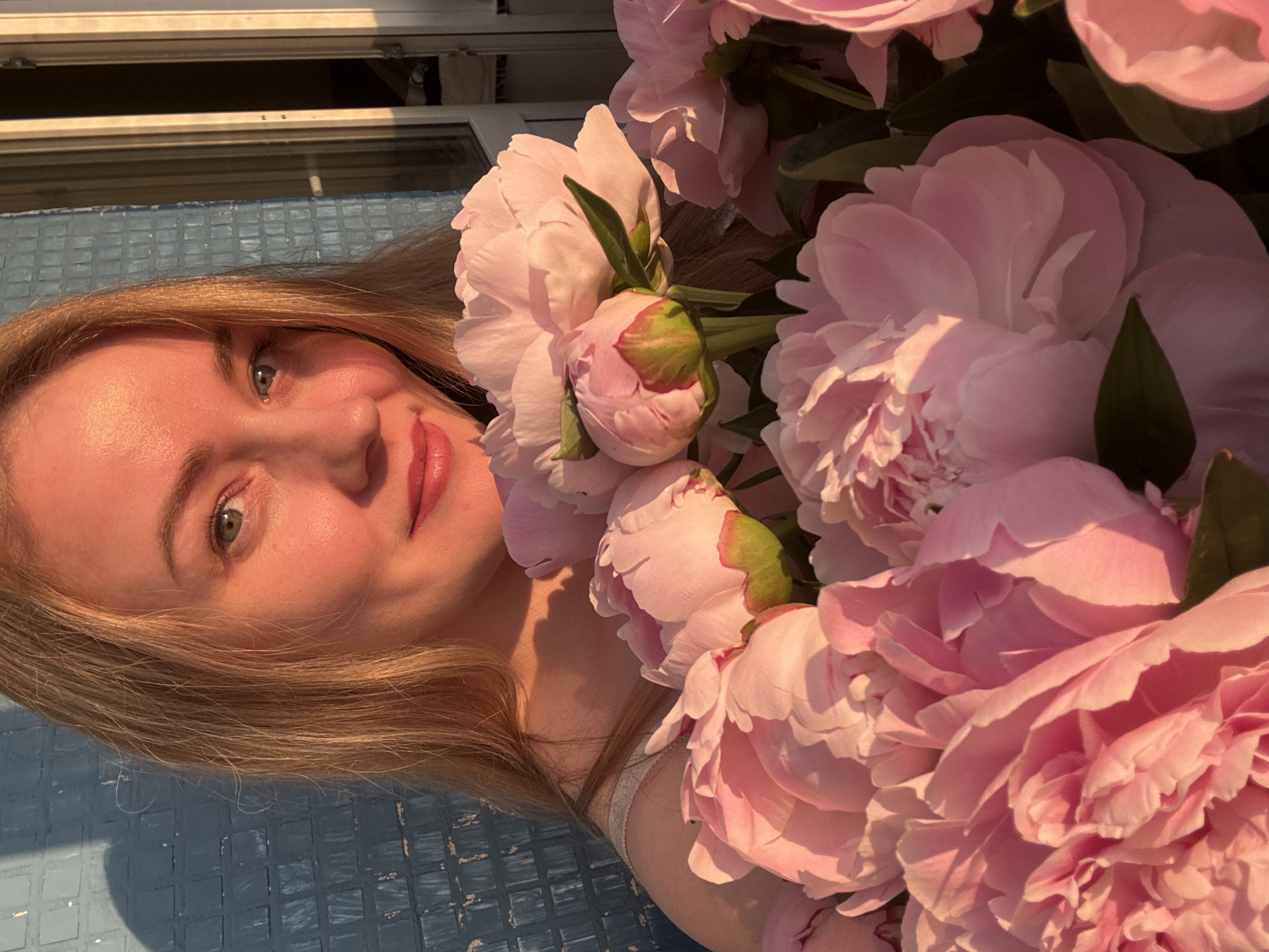 Woman with pink peonies photographed during Chaikovsky sunset session