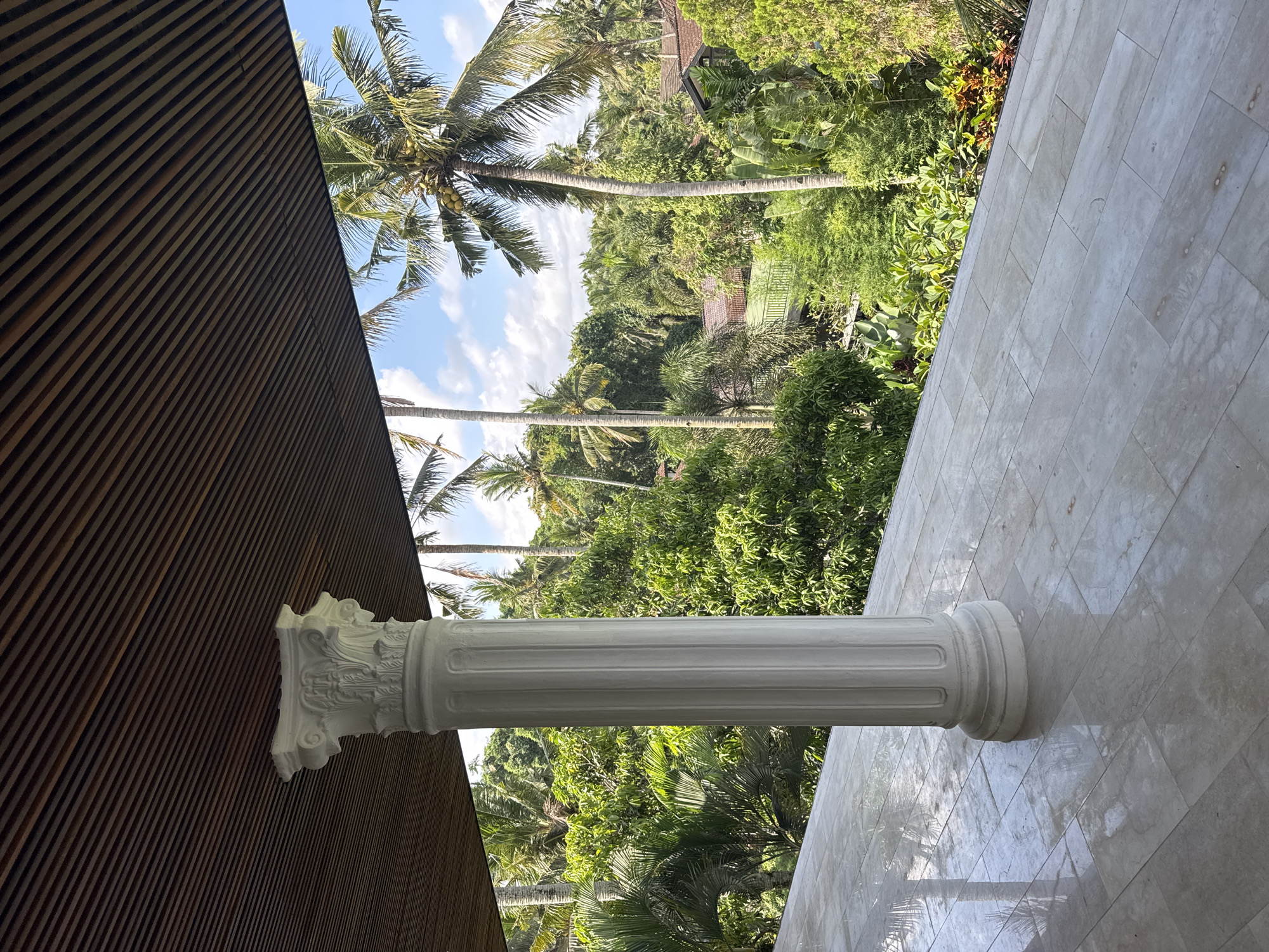 Classical column spotted amid tropical landscape in Tampaksiring
