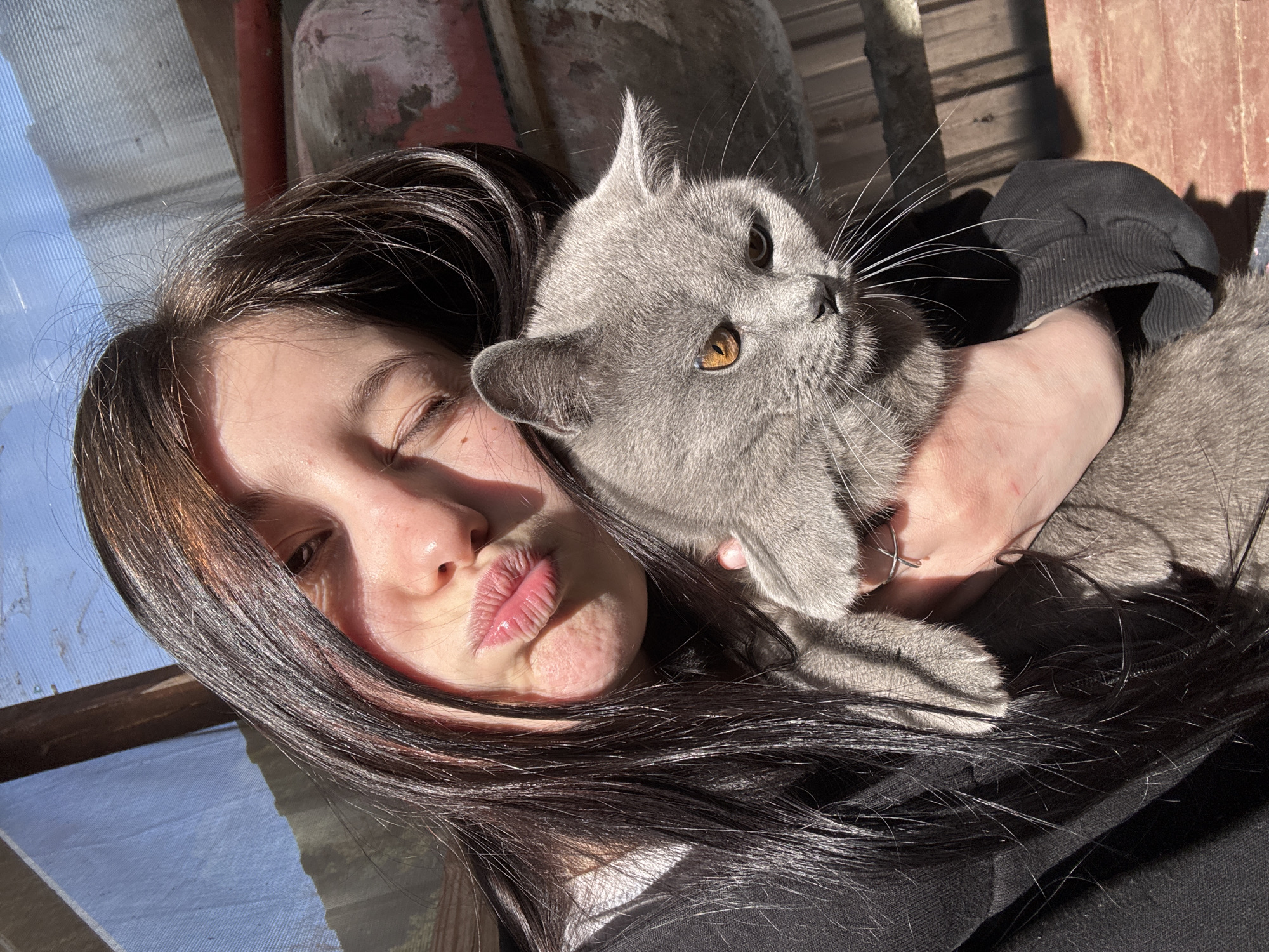 Woman and grey cat share playful morning moments in rural Russia