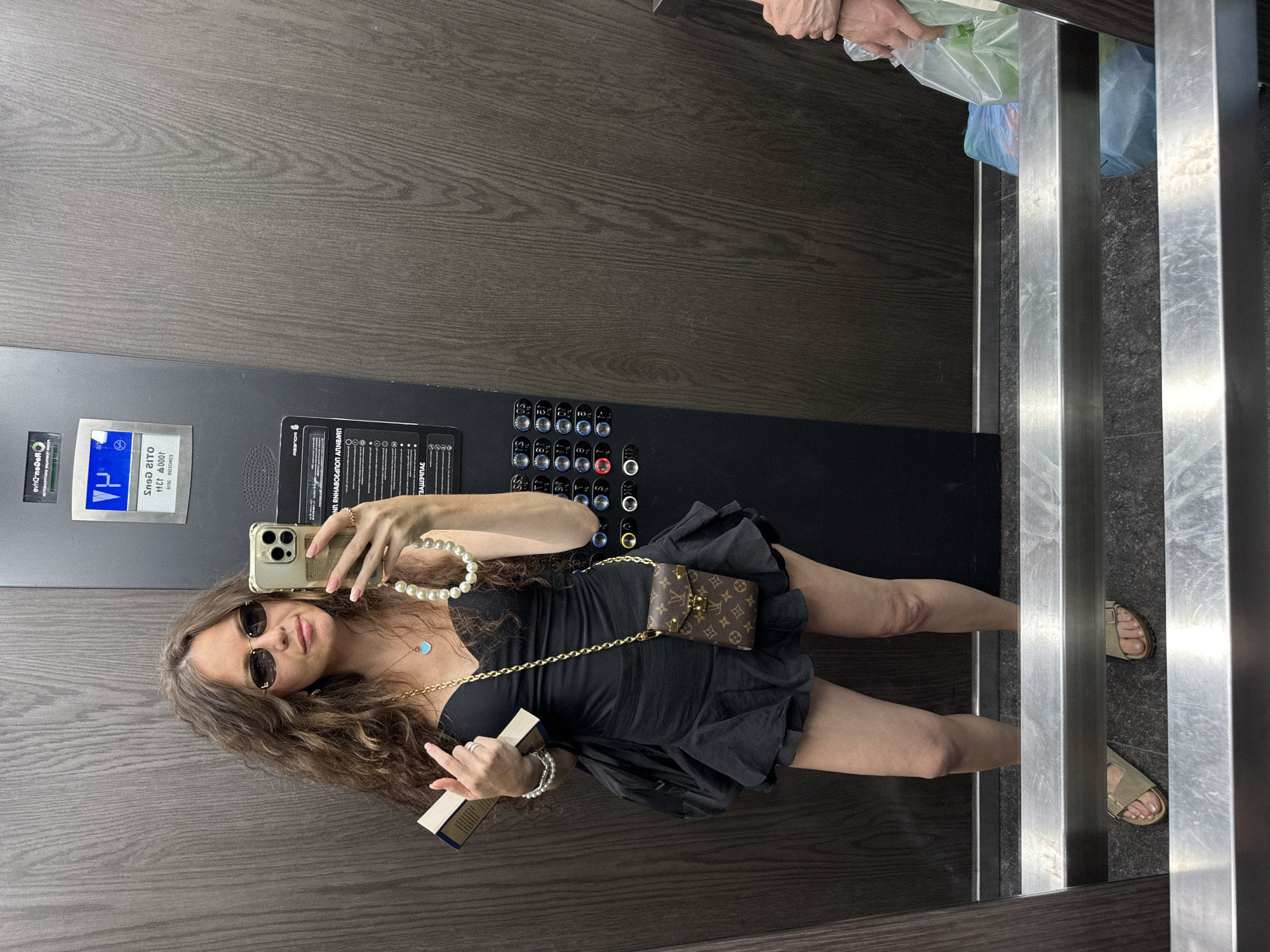 Elevator mirror selfie, accessorized and book in hand