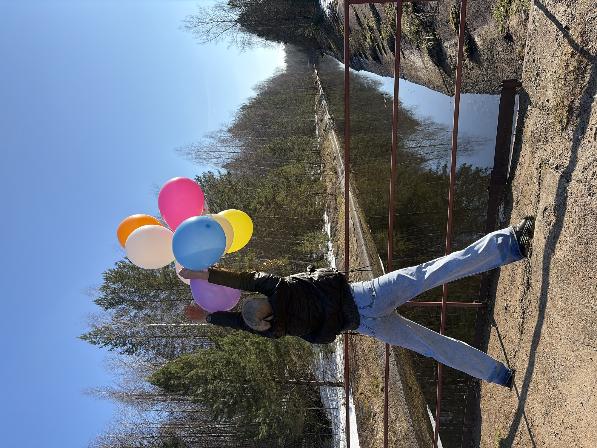 Woman poses with balloons, umbrella at Chernushka waterfall
