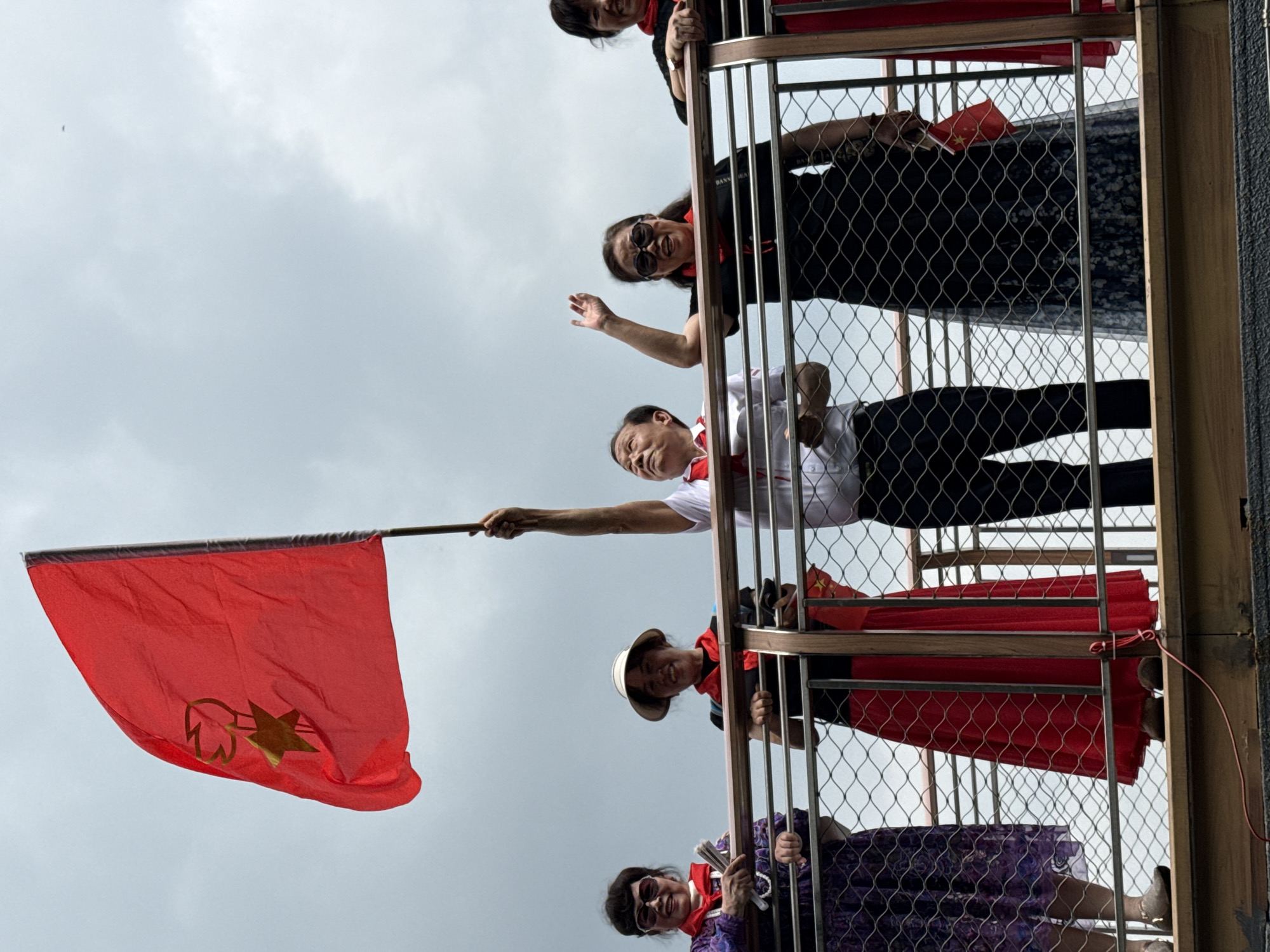 Group gathers on balcony with Chinese flag in Chongqing