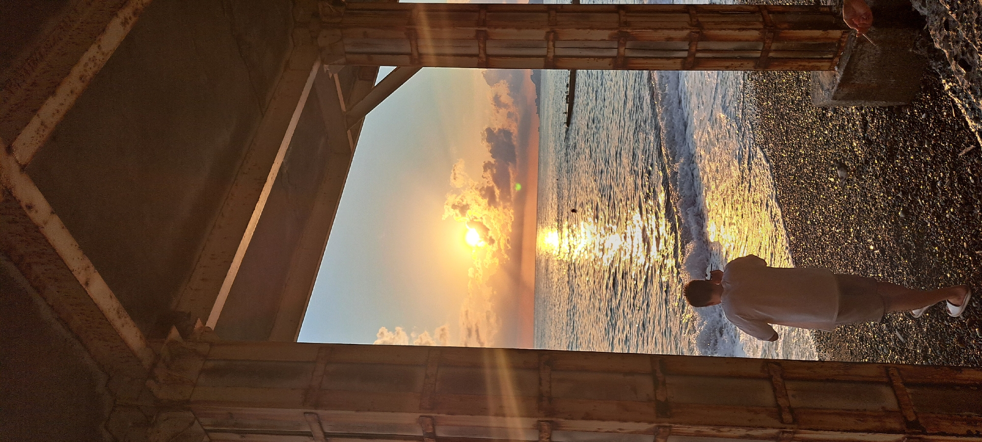 Sunset over the Black Sea, framed by rusted metal in Sochi