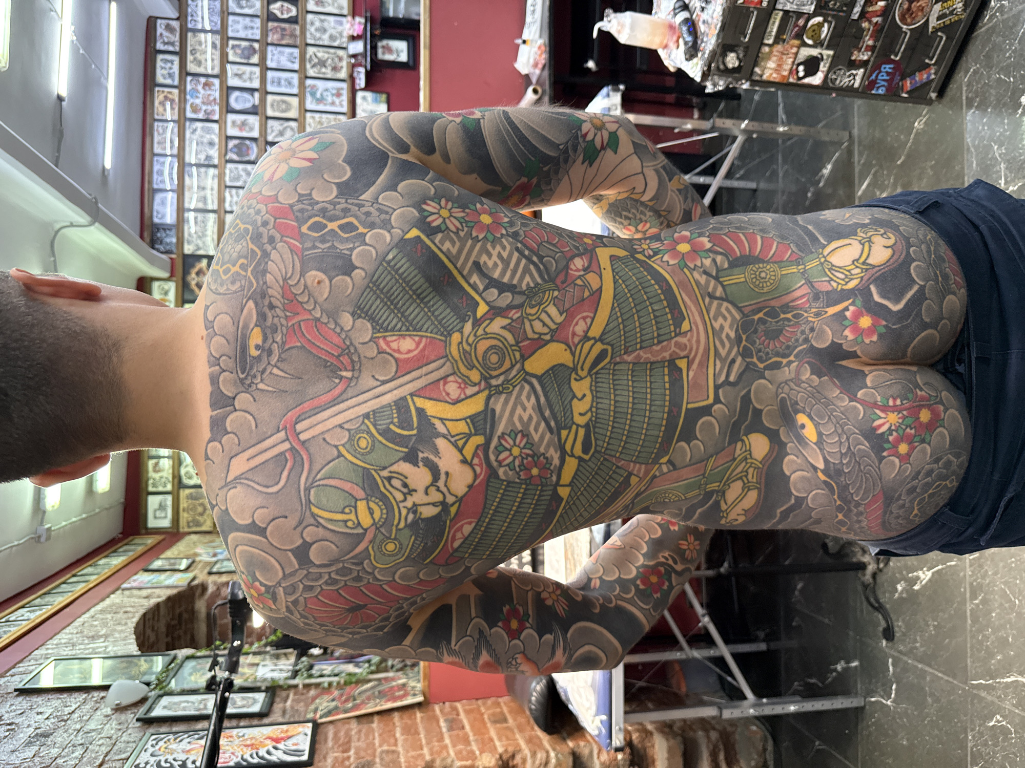 Heavily tattooed man documented in Moscow featuring Japanese, tribal artwork