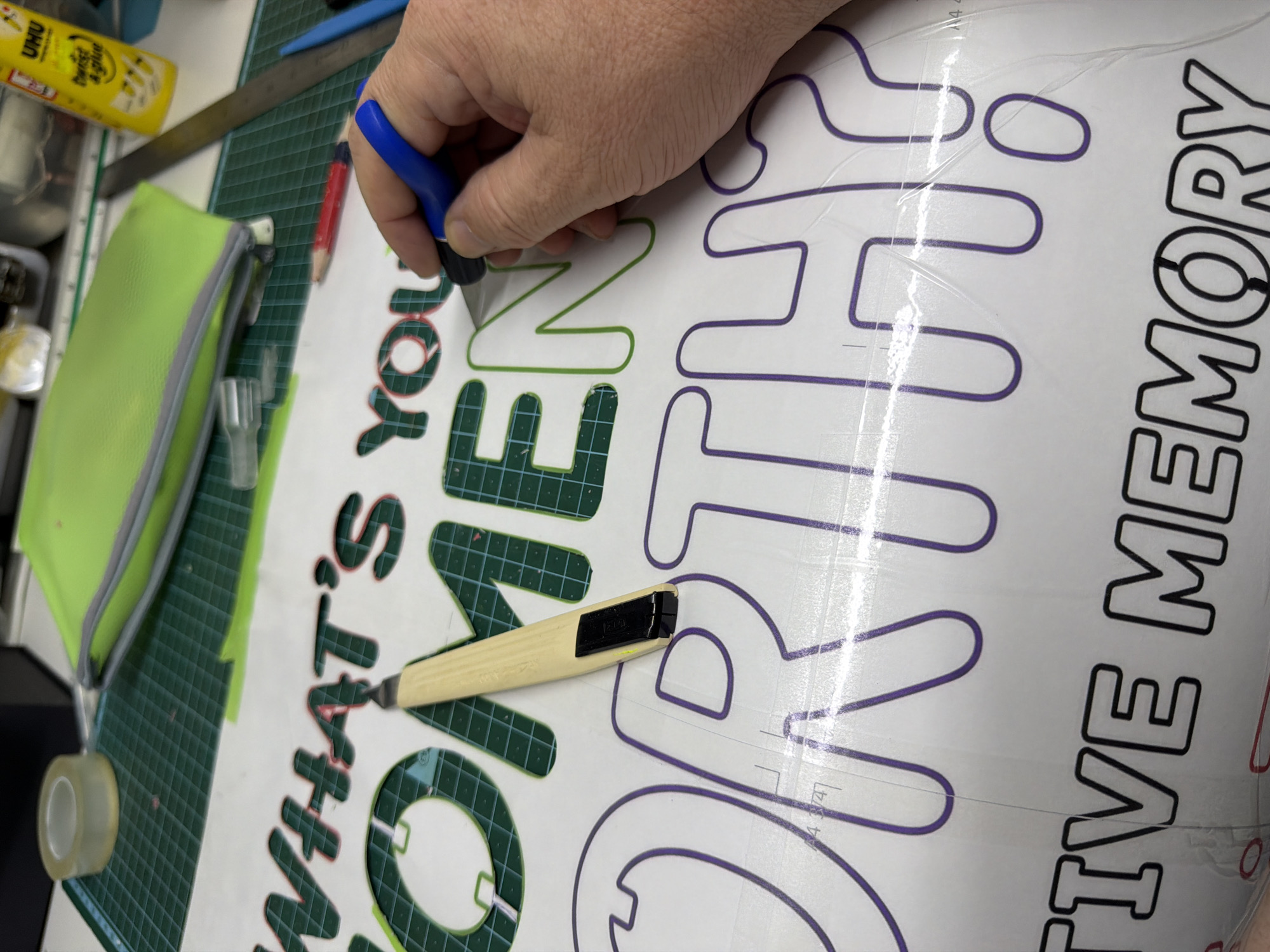Craft worker cuts vinyl lettering in Even Yehuda workshop