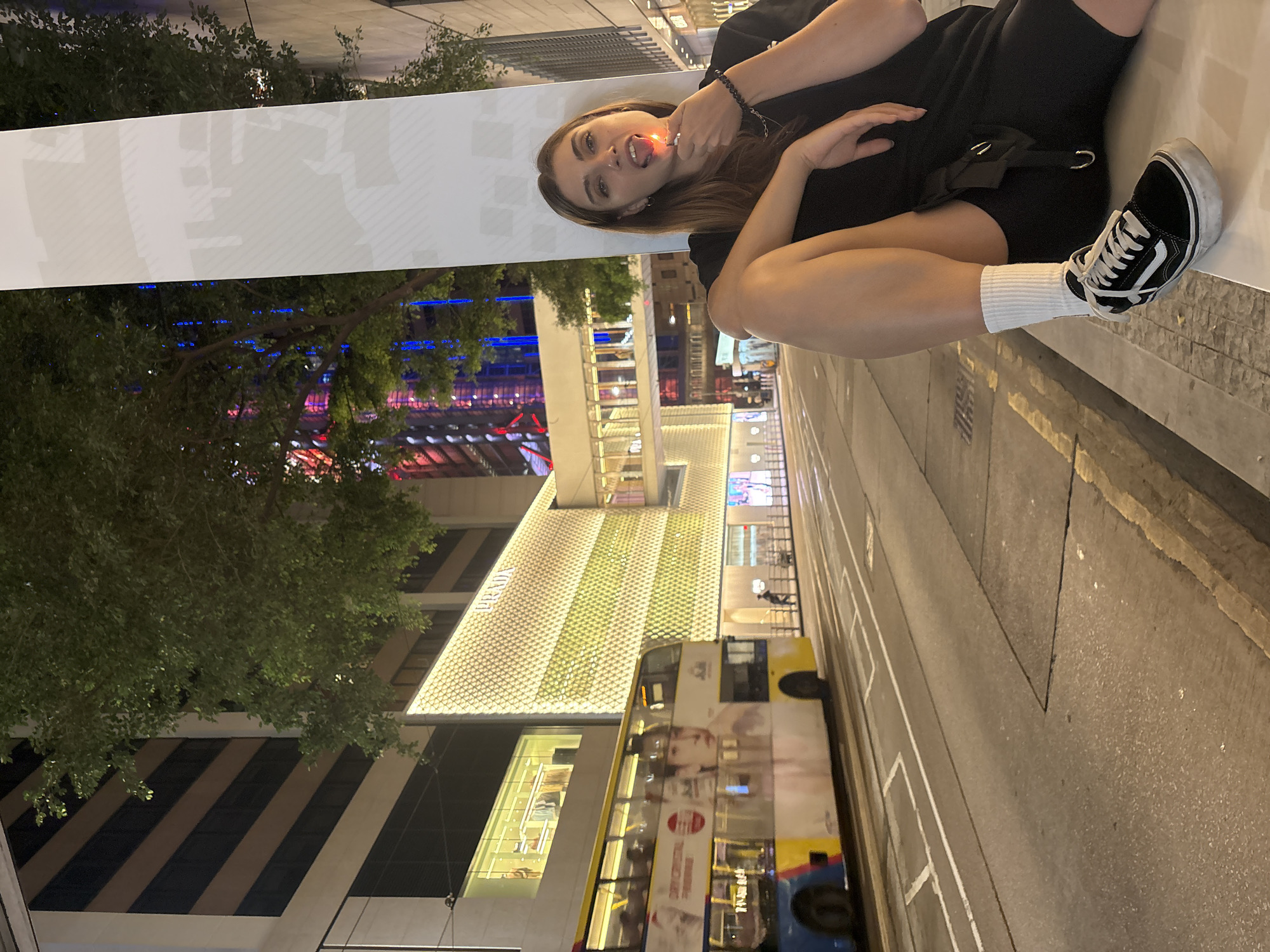 Woman sits on ledge holding lighter in Hong Kong