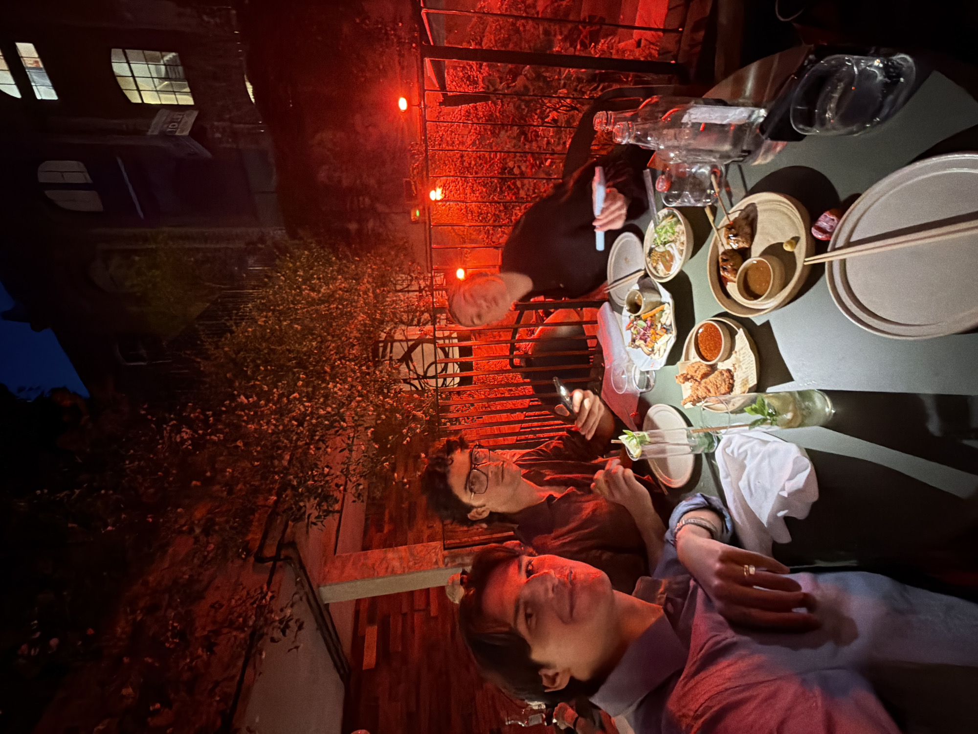 Late-night outdoor dining in London, red-lit rooftop setting