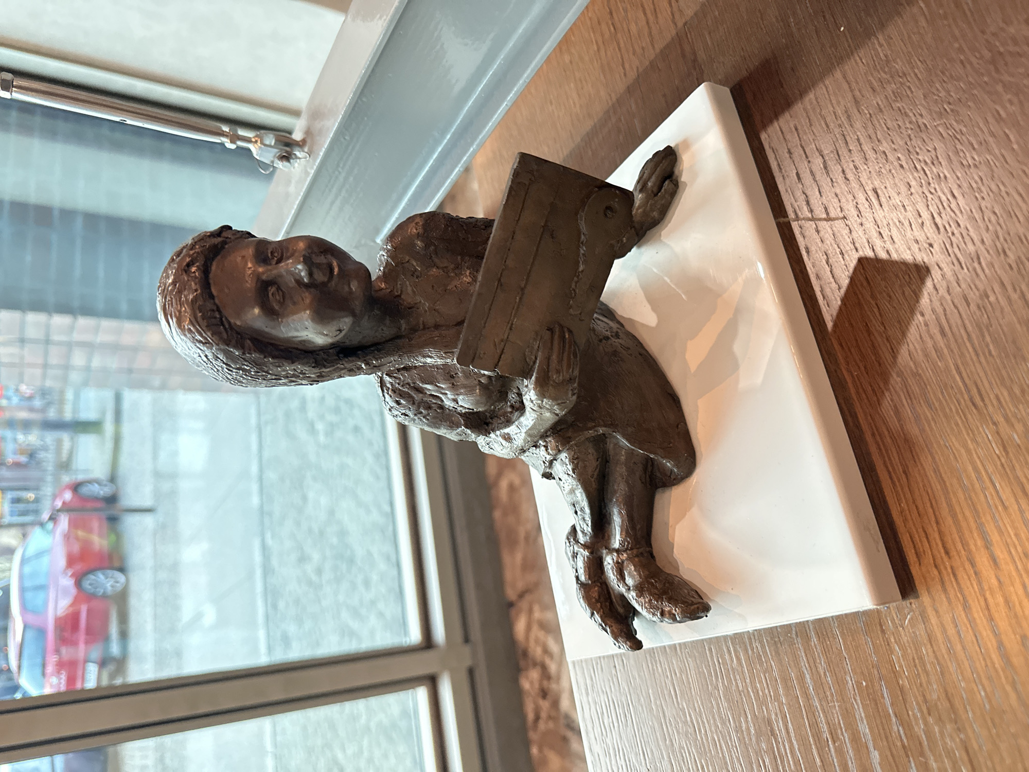 Bronze reading child sculpture observed on table in Wrocław