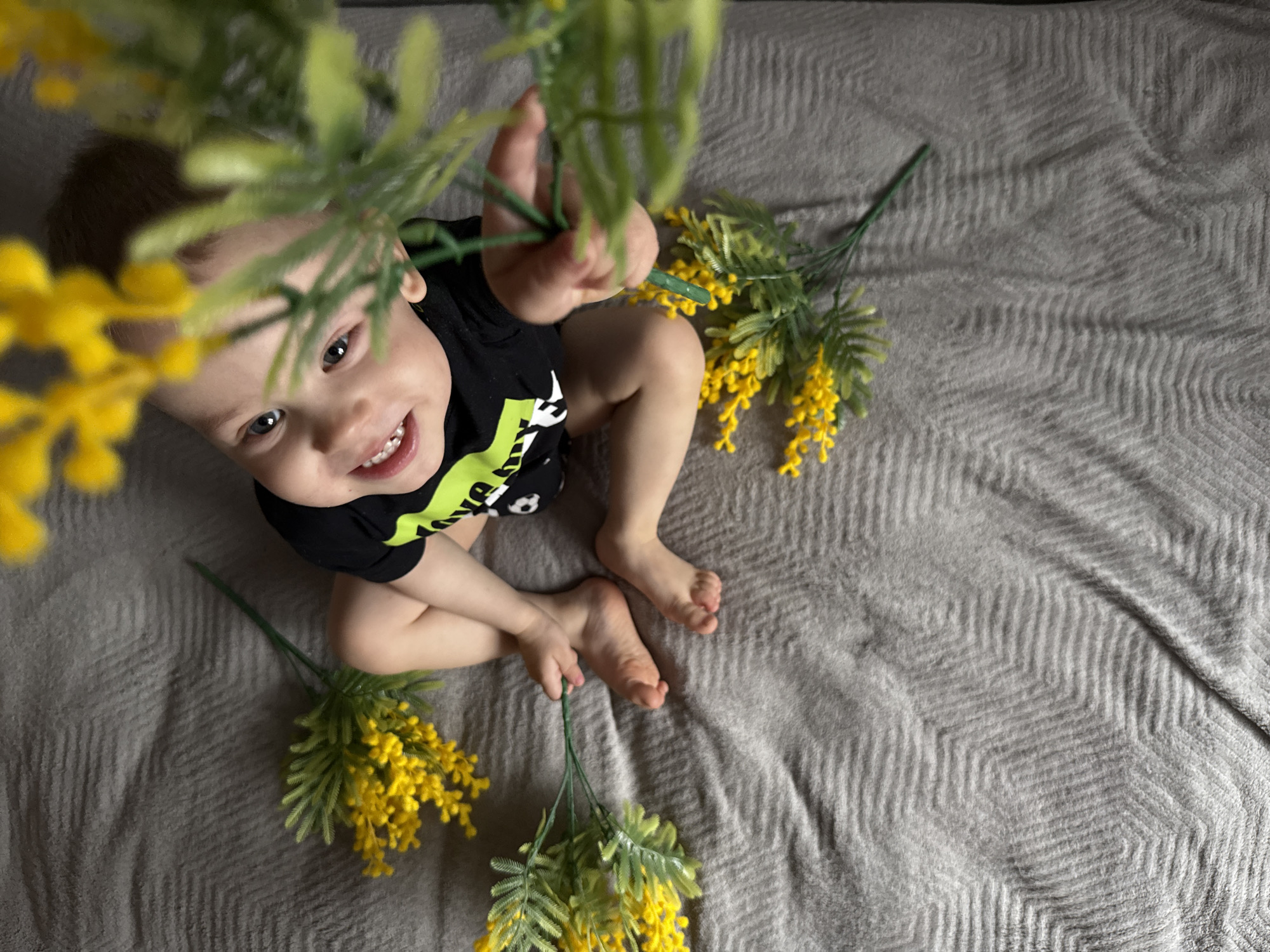 Toddler sits on blanket with yellow flowers in Fedorino